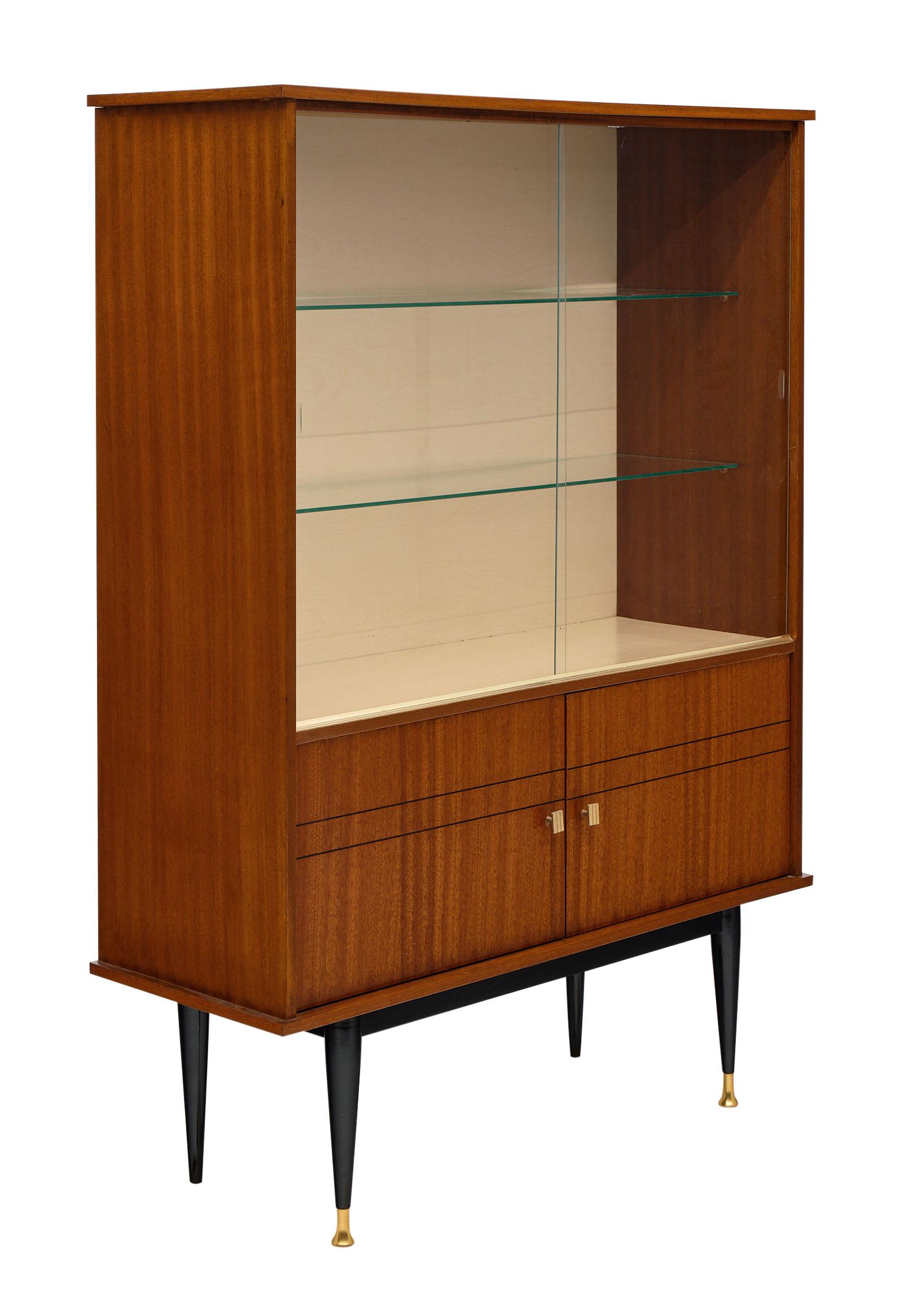 Mid-Century rosewood French silver cabinet with glass shelving behind two original glass sliding doors. We love the detail of this elegant piece and the tapered; ebonized legs capped with brass. the bottom doors open out for additional storage.