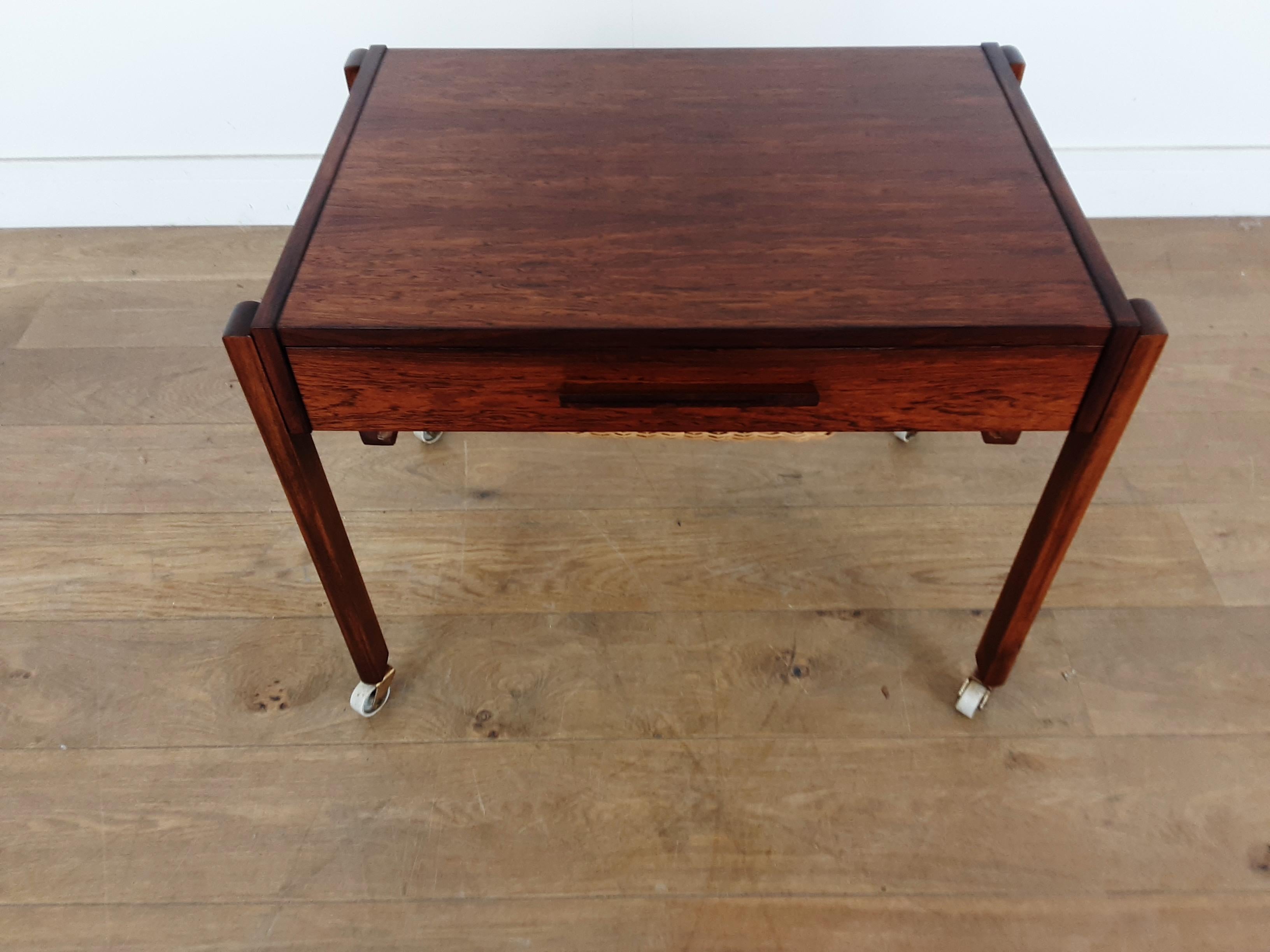 Midcentury rosewood sewing table, or work table.
A very practical table with two drawers, the lower drawer with inset wicker basket, the top drawer sectioned for storage.
On caster for easy mobility.
Measures: 52 cm H 67.5 cm W 46 cm D tabletop