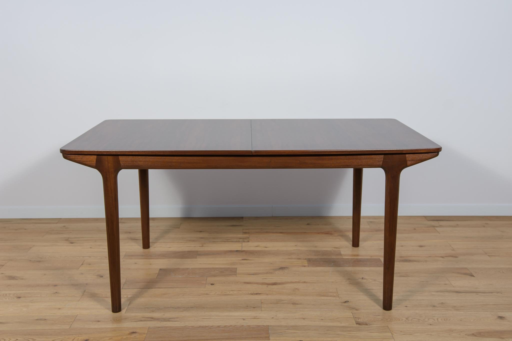 A rare model of a rectangular table with two mechanically opened extensions. The table top is veneered with rosewood, the legs and frame are made of teak. Table made  by the British McIntosh manufactory in the 1960s. The table has undergone a
