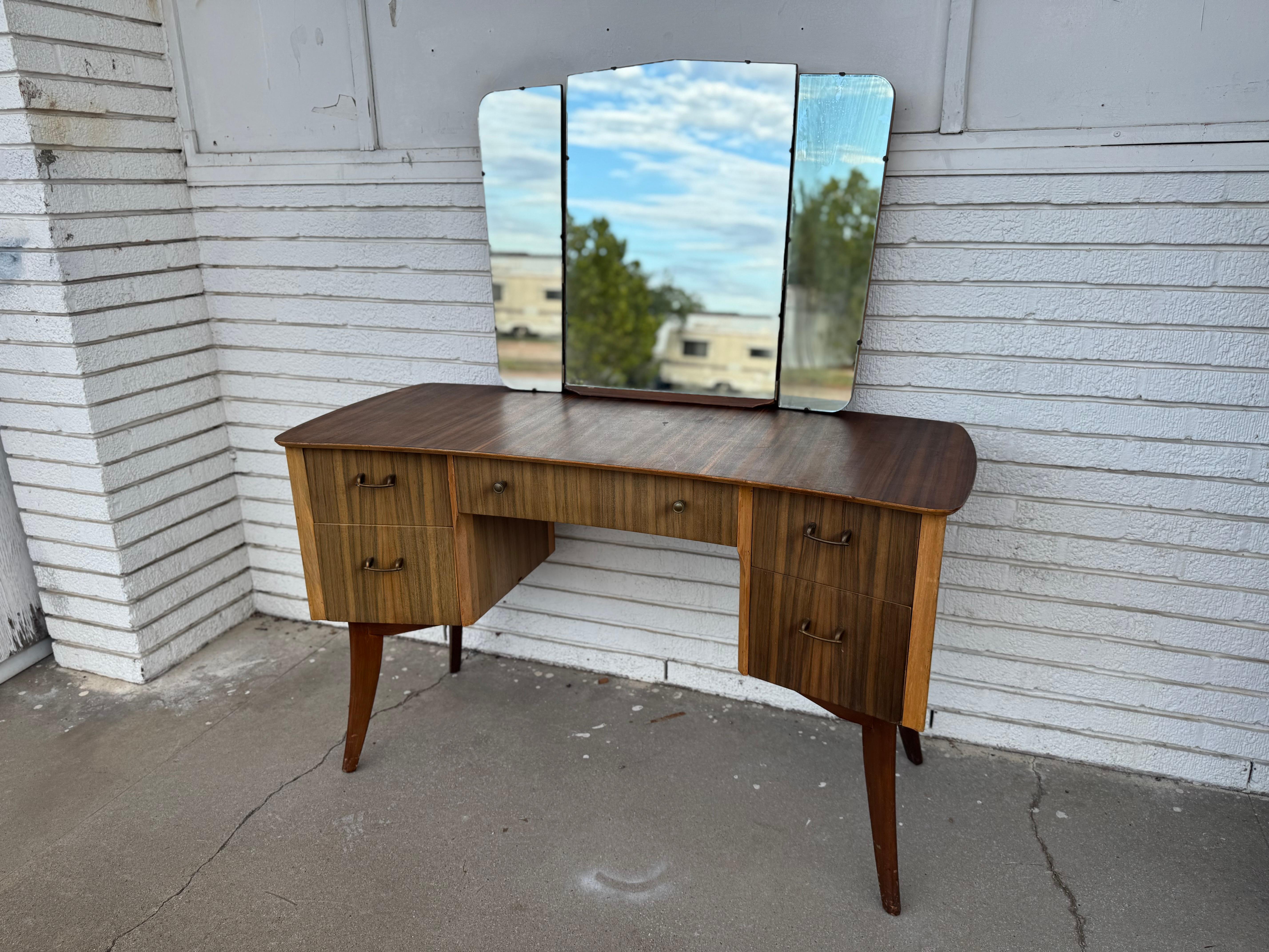 Si tratta di un bel mobiletto moderno di metà secolo con triplo specchio.
Il vanity è realizzato in un bel legno di palissandro con motivo a nastro.
Questo pezzo è piuttosto scultoreo.
