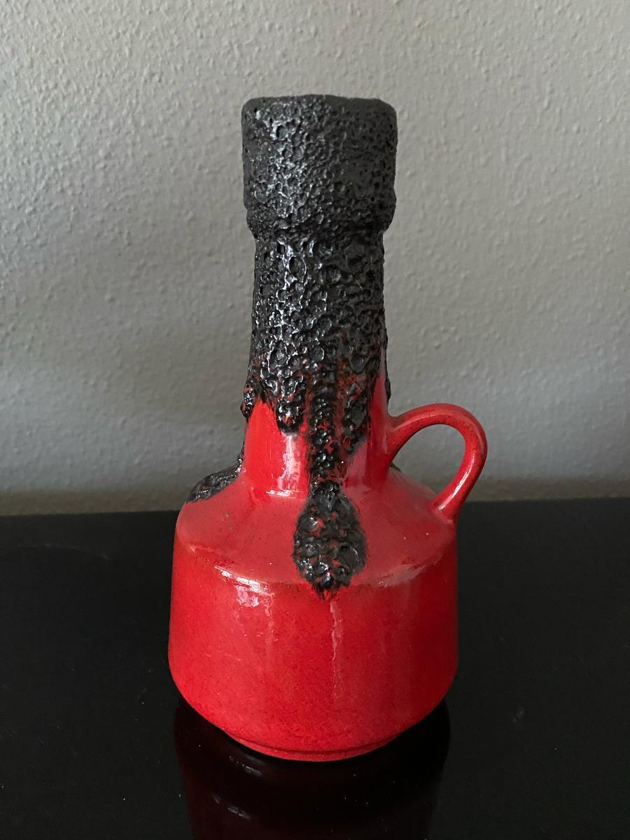 A Roth Keramik vase, with a matte bubbly 'lava' glaze thickly poured over a glossy red glaze.
Measures: height: 20cm and depth: 10cm.
