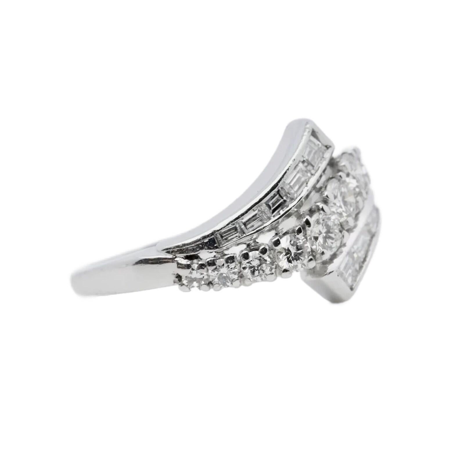 A hand crafted mid century diamond bypass ring in platinum. Featuring ten baguette cut and eleven round brilliant cut diamonds. The diamonds grade as E/F color, and VS1 clarity with a combined weight of 0.85 carats.

In excellent condition, this