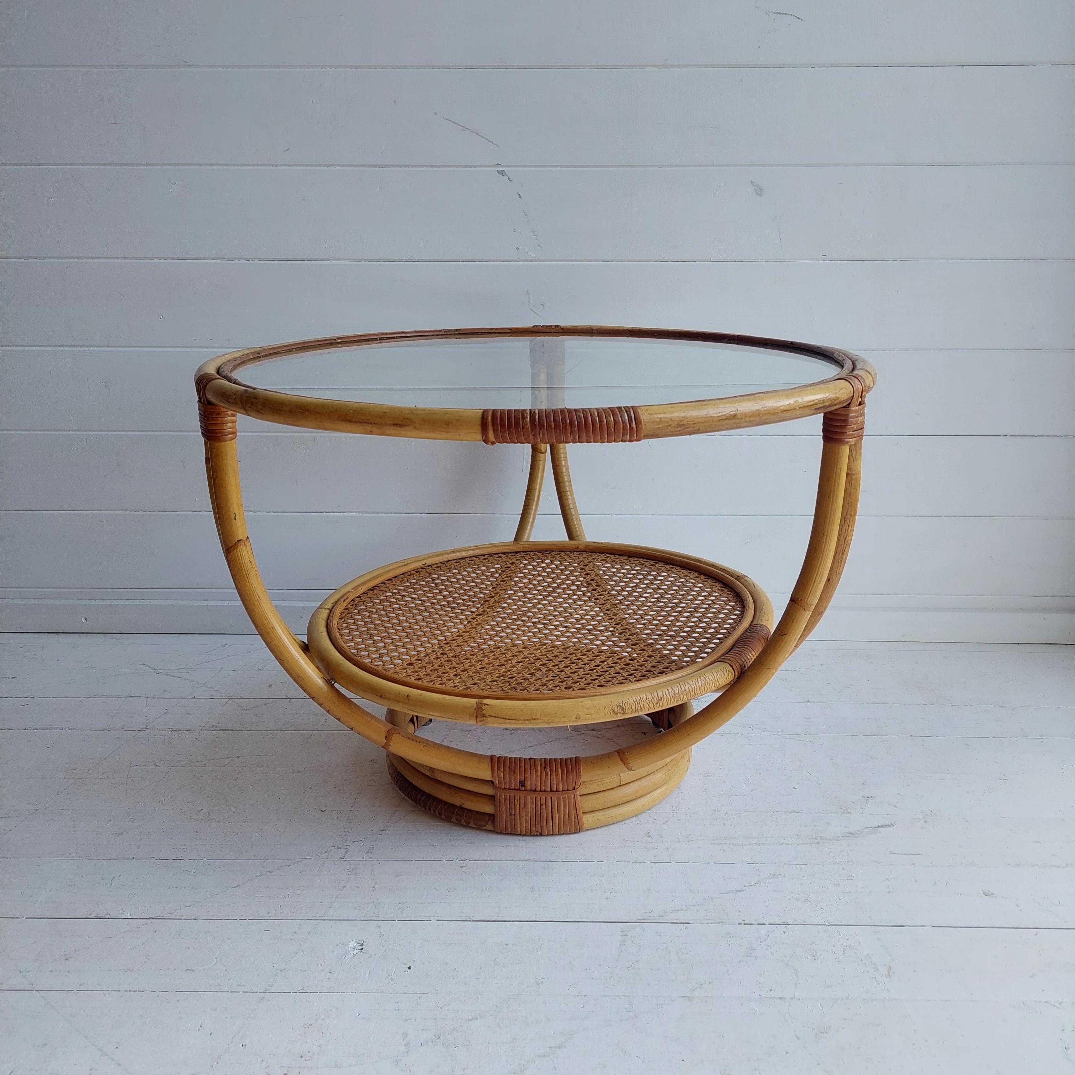 Cool vintage coffee table
This is a rare find!
This beautiful circular glass top table is both stylish & functional. 
It has a cane topped lower shelf which adds to its Mid-Century vibe.

The table has an iconic mid-century design echoing the