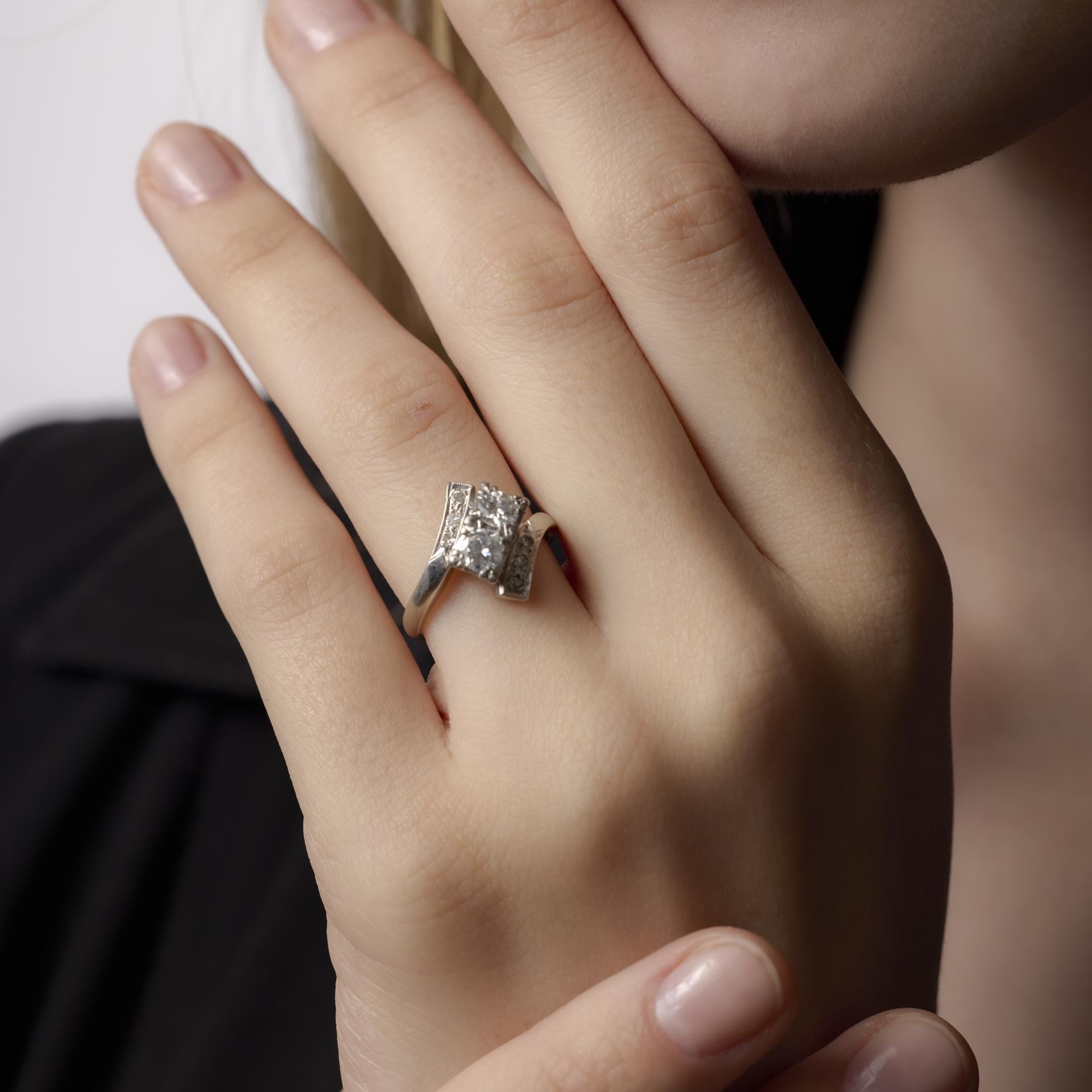 Questo elegante anello in oro bianco 14k del Mid Century mette in mostra due radiosi diamanti incorniciati da delicati accenti, fondendo una raffinatezza senza tempo con un classico fascino vintage.