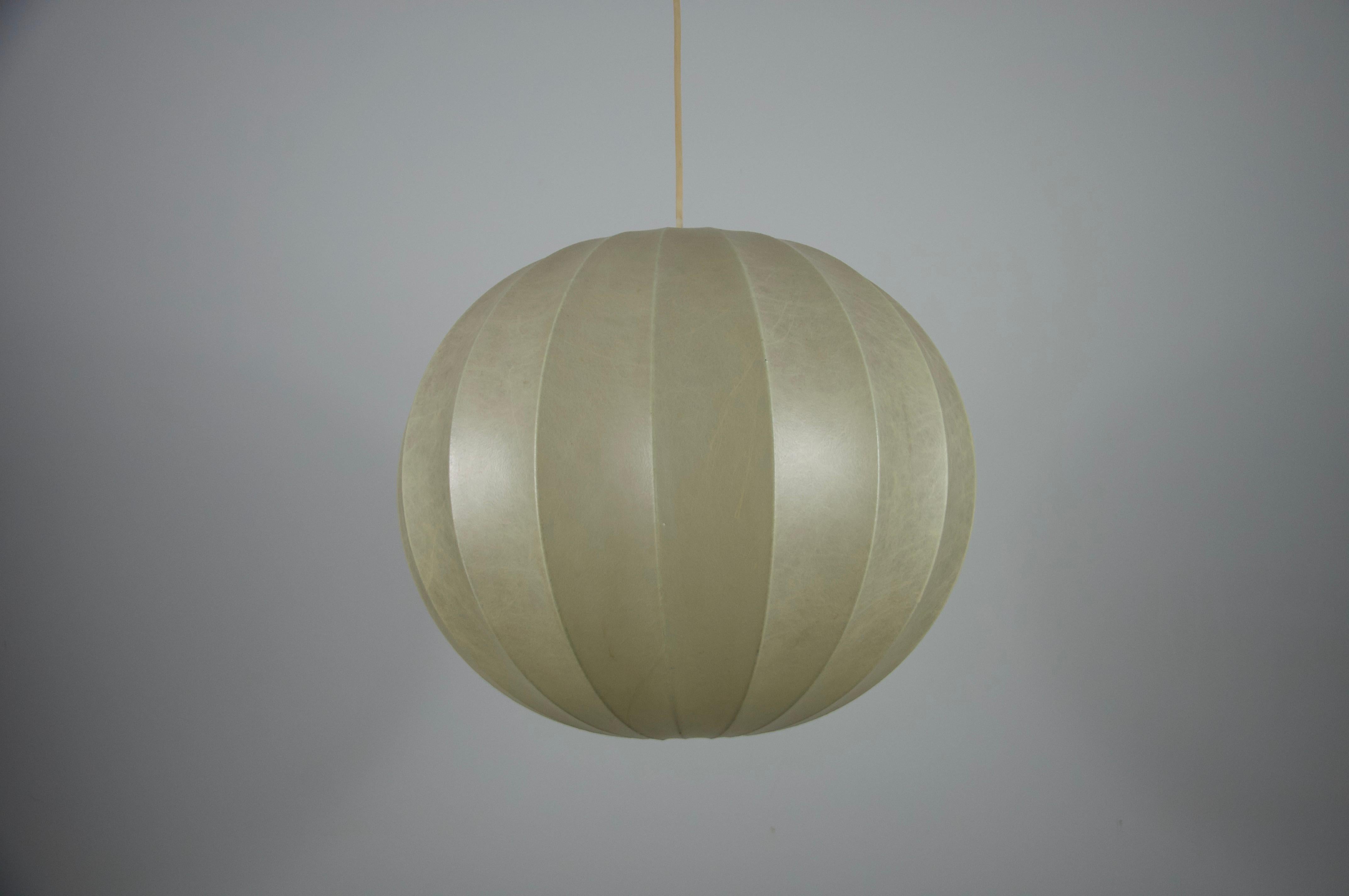 Si tratta di una lampada a sospensione a bozzolo realizzata in Italia negli anni '60, che mette in mostra l'eleganza e l'innovazione del design italiano di metà secolo. La lampada presenta una forma rotonda di straordinaria bellezza, che ricorda gli