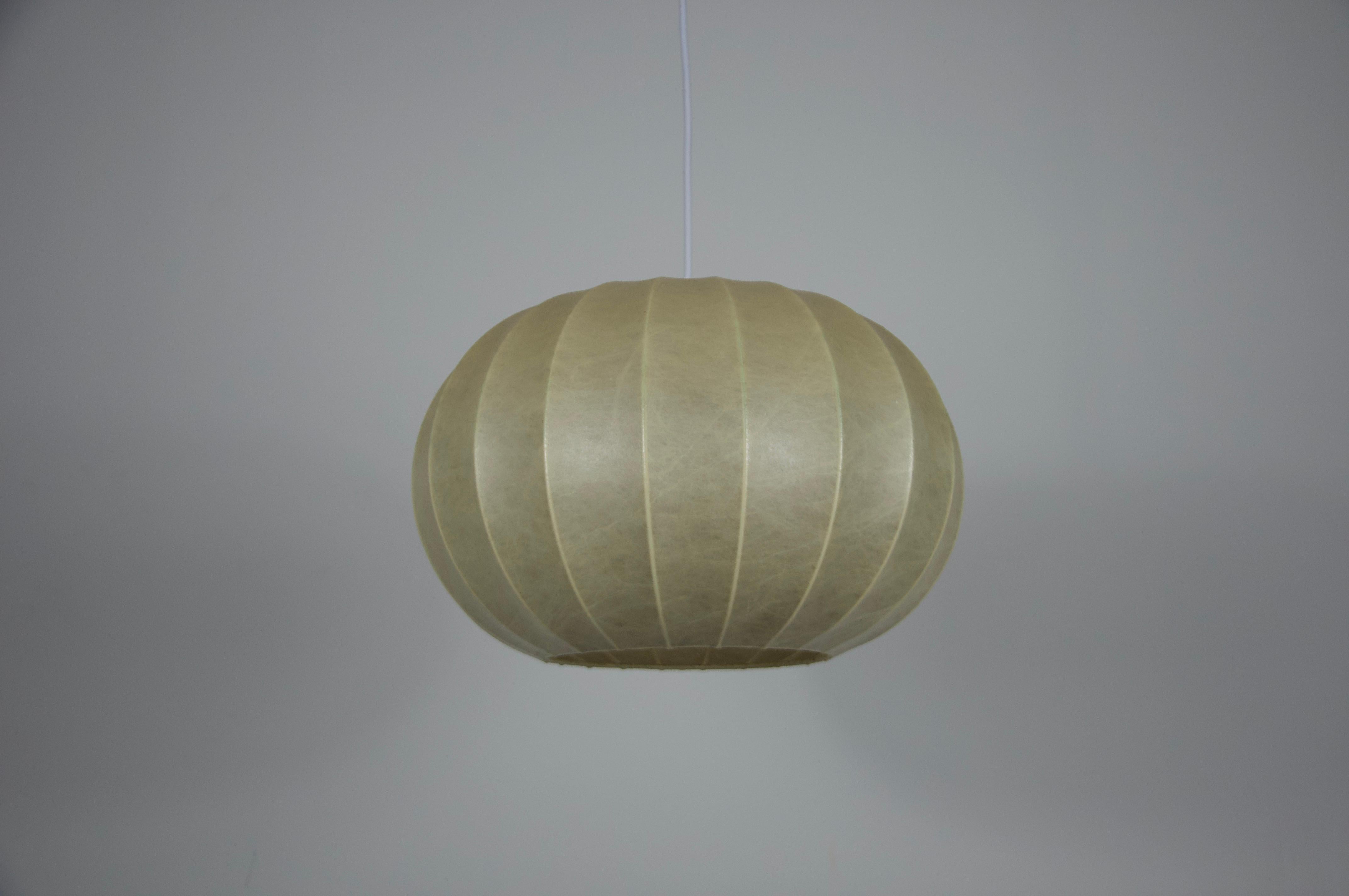 Questa lampada a sospensione rotonda a bozzolo della metà del secolo scorso è stata realizzata in Italia negli anni Sessanta. La sua forma organica è stata creata con l'innovativa tecnica del bozzolo, in cui un materiale fibroso resinato viene steso