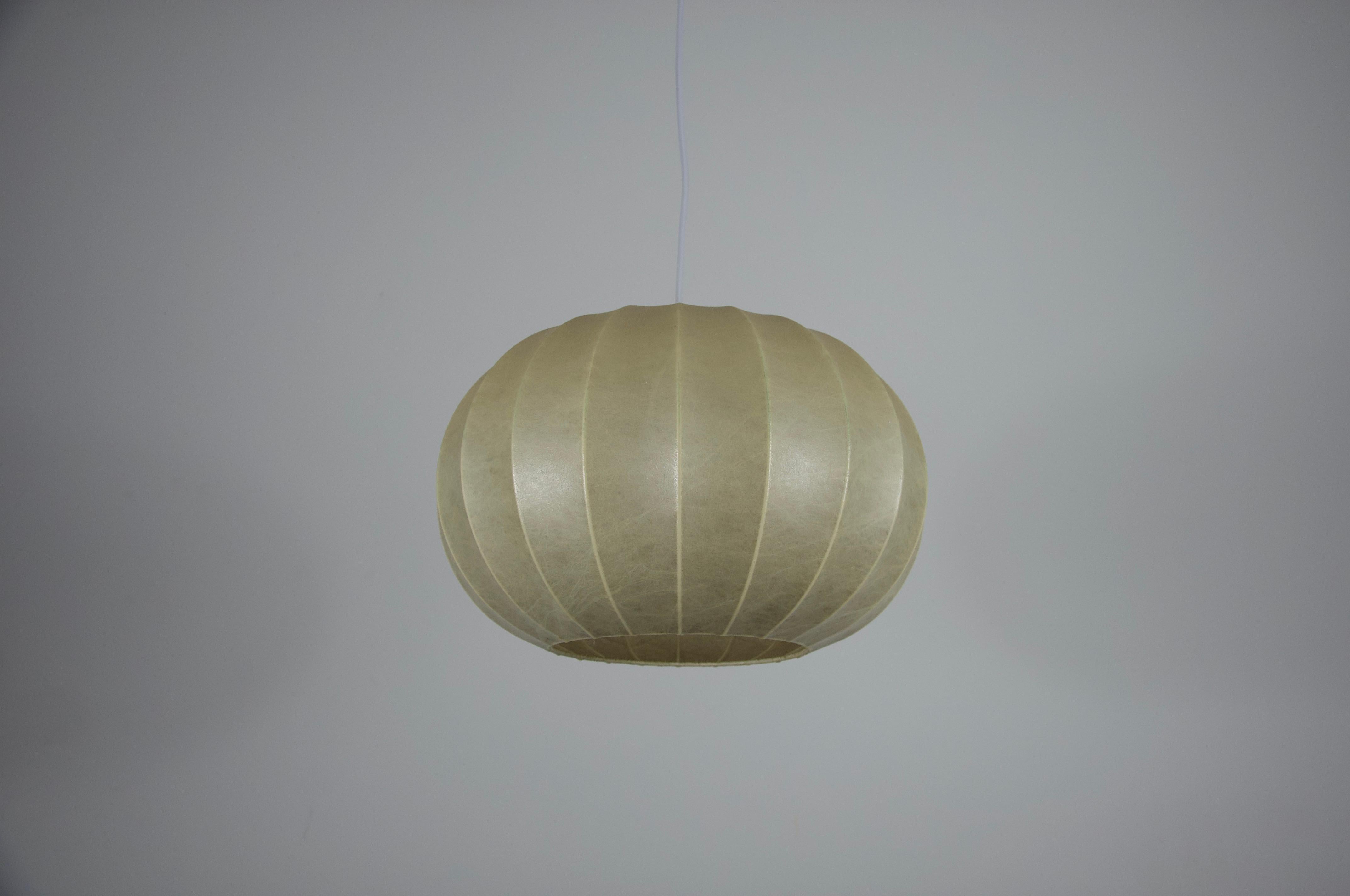 Questa lampada a sospensione rotonda a bozzolo della metà del secolo scorso è stata realizzata in Italia negli anni Sessanta. La sua forma organica è stata creata con l'innovativa tecnica del bozzolo, in cui un materiale fibroso resinato viene steso