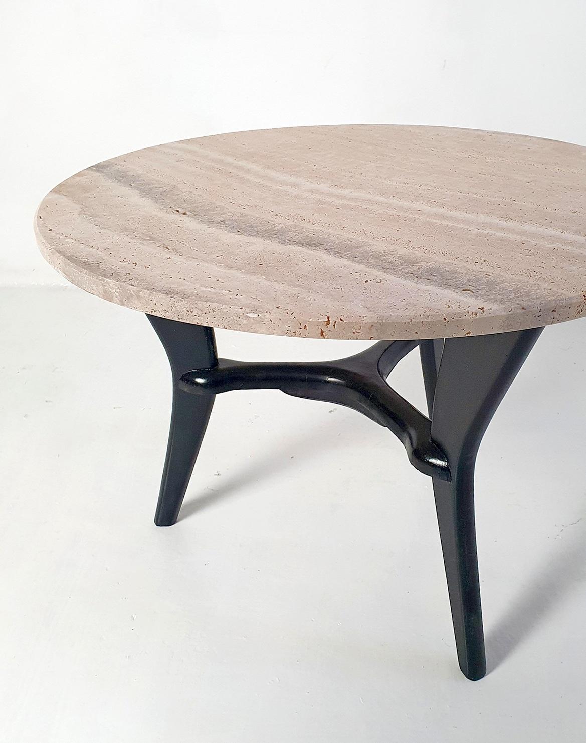 Voici une remarquable table basse datant de l'âge d'or du design italien - les années 1950. Cette pièce élégante est dotée d'une base tripode sculpturale unique en son genre, fabriquée en bois noirci, évoquant un sentiment de mouvement et de