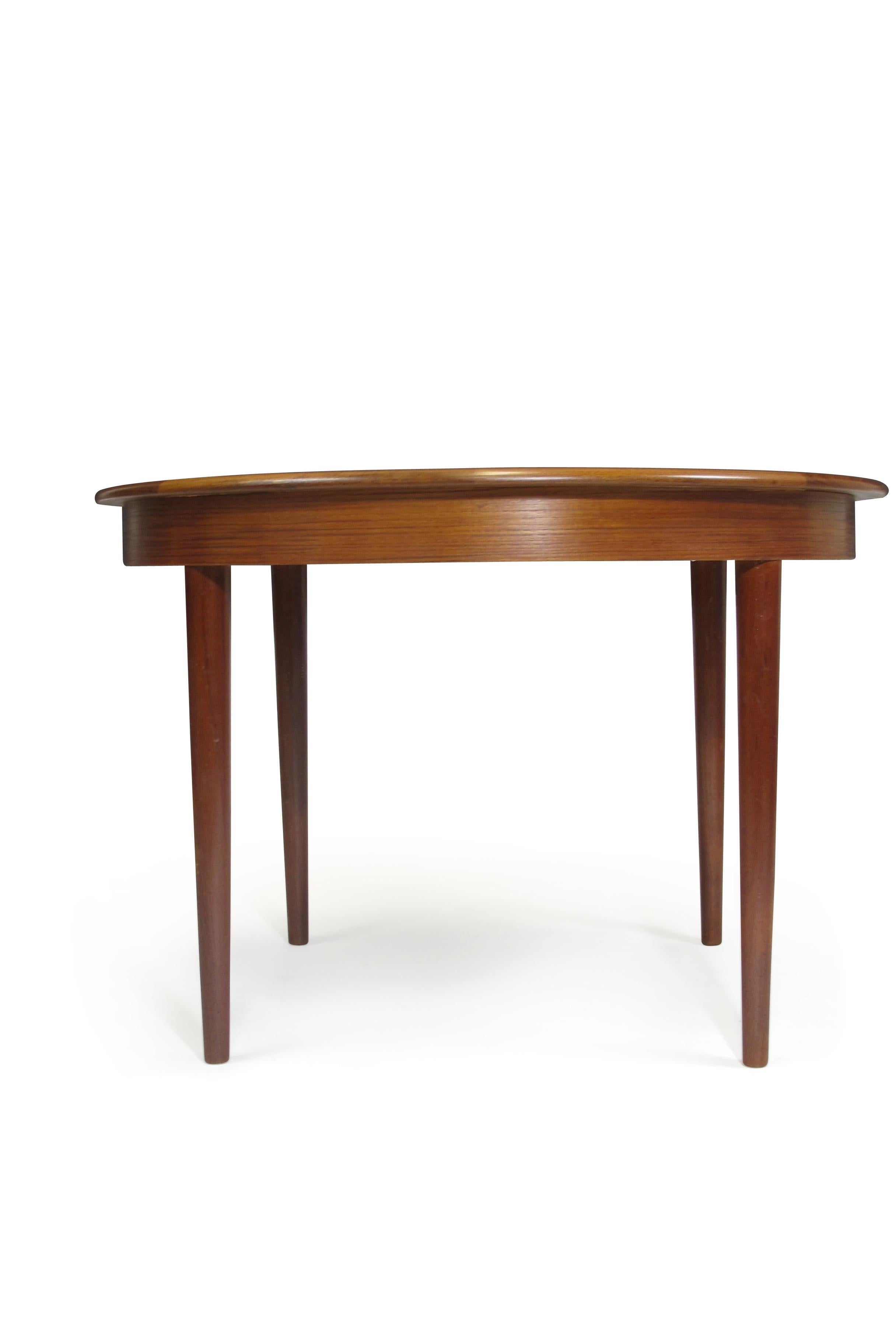 Round dining table with octagonal edge banding detail and three leaves. Crafted of old-growth teak arranged for bookmatched grain. Table seats 4 closed and 10 fully expanded. Finely restored by hand with natural oils. Measurements: Round - 43.25