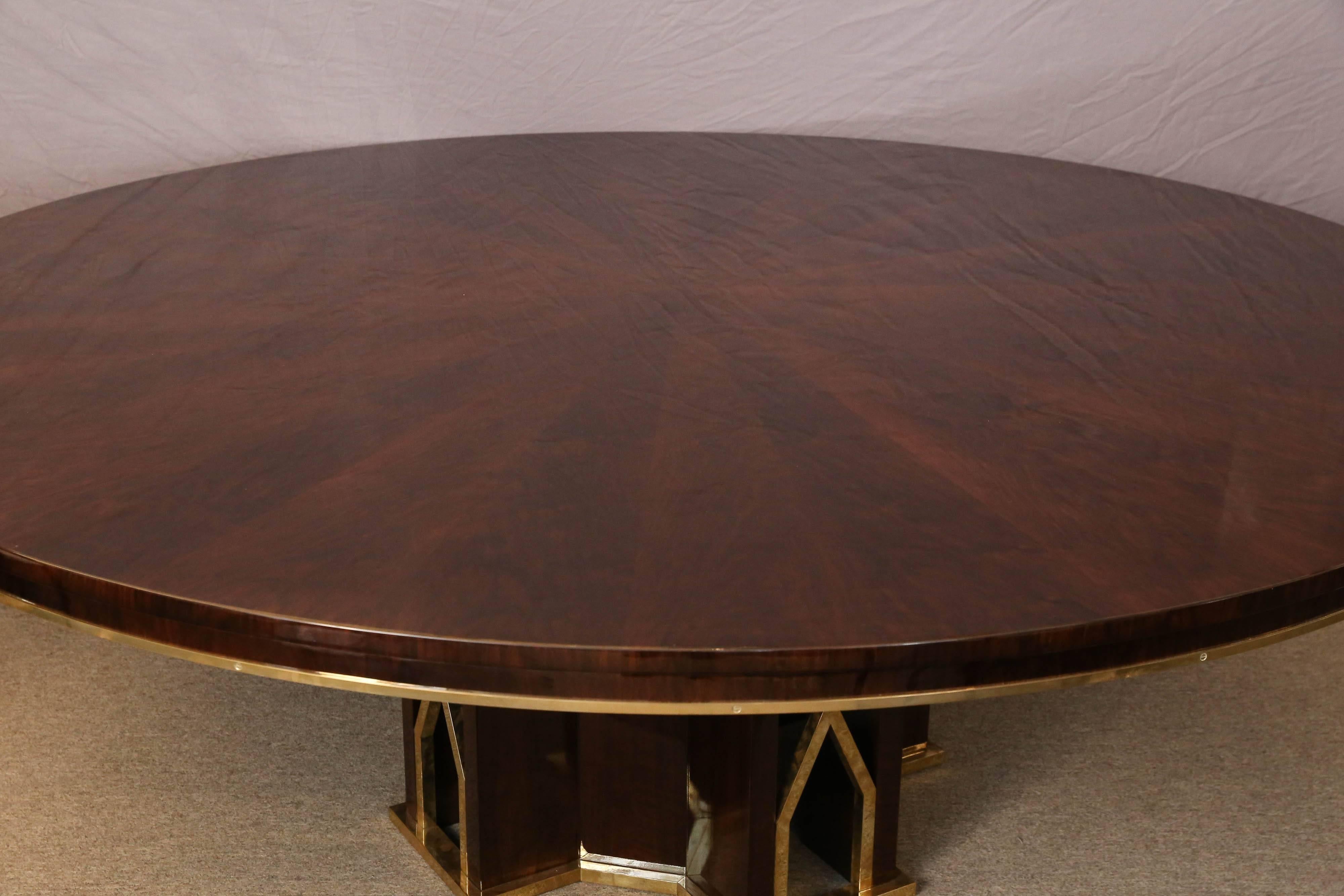 Table has a round table top, that is decorated with brass trimming on the lower edge. It is elevated by the octagonal shape base, that is also embellished with several brass decorative elements. Table can accommodate around ten chairs.

Condition