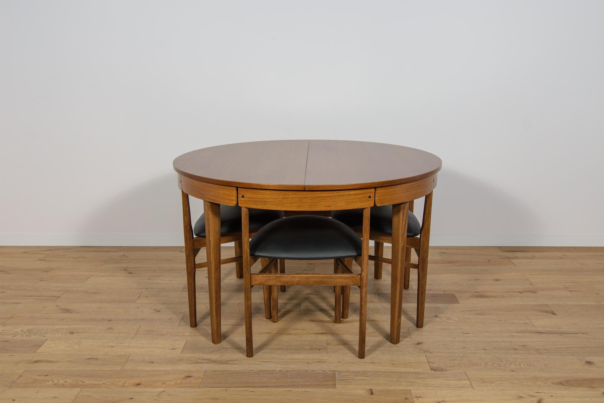 A set of table and four chairs manufactured in the British Mclntosh manufacture in the 1960s. Chairs fitted into the edge of the table. Furniture after a comprehensive carpentry and upholstery renovation. Wooden elements are made of teak wood. The