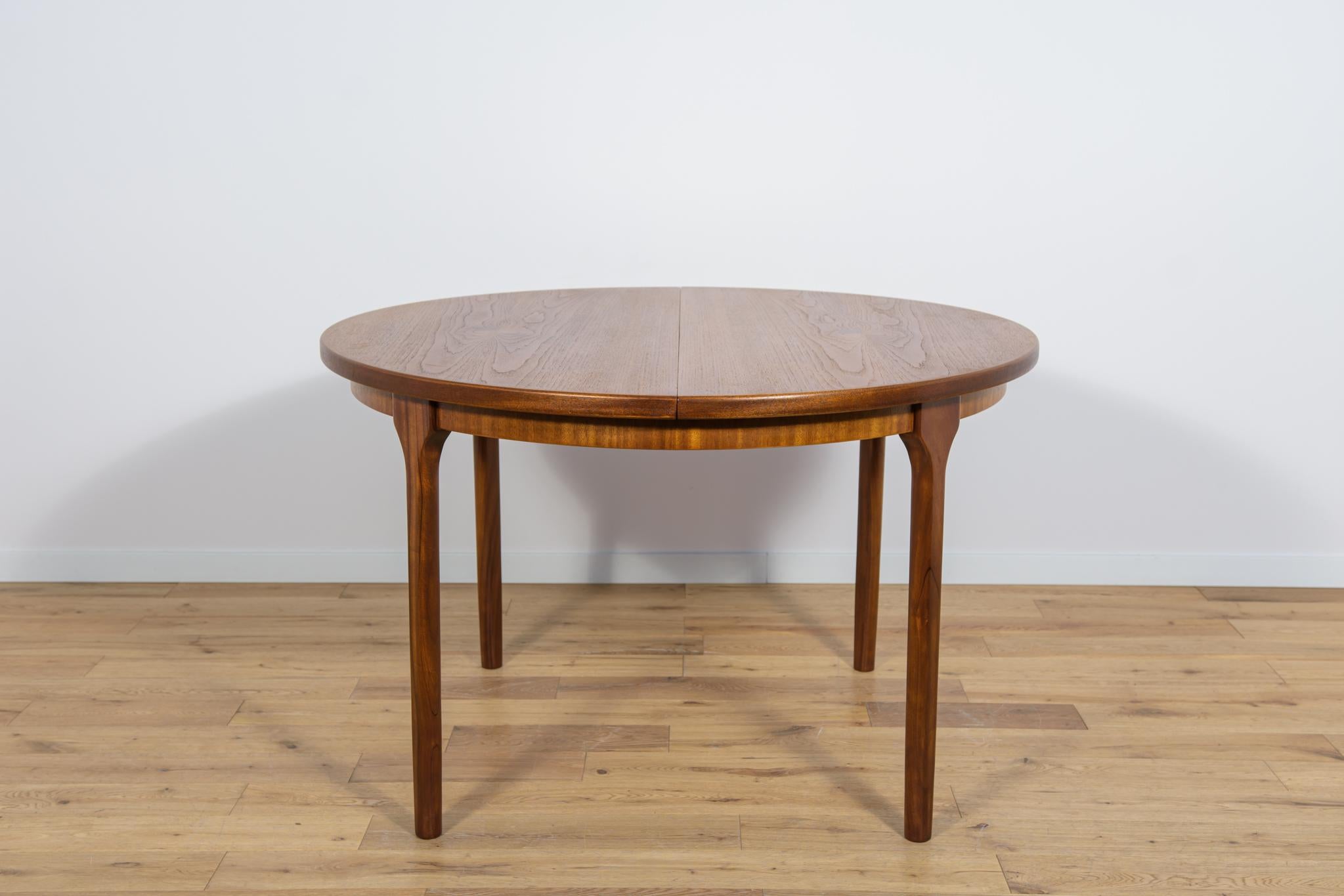 This round extendable dining table was produced by McIntosh in the 1960s. The table has profiled legs that give it a unique character and elegance. Teak elements cleaned from the old surface and painted in an oak stain and finished with quality
