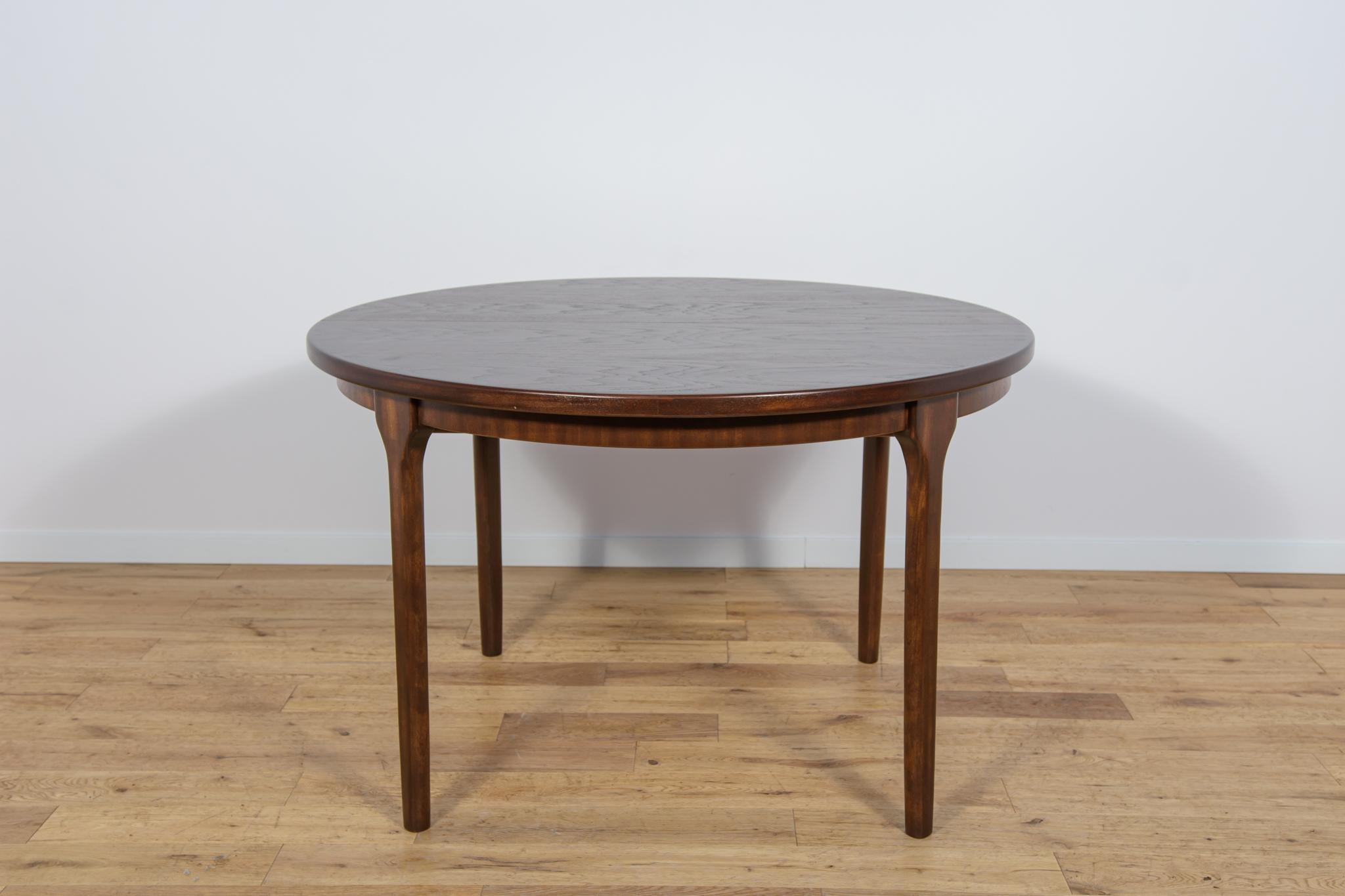 This round extendable dining table was produced by McIntosh in the 1960s. Teak elements cleaned from the old surface and painted rosewood stain and finished with strong semi matte lacquer. The dining table has a mechanism that facilitates unfolding.