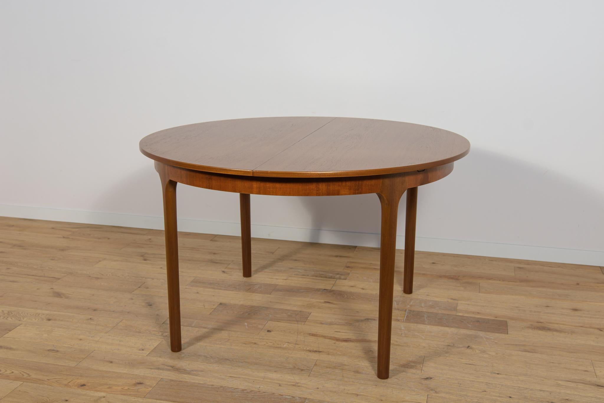 Esta mesa de comedor redonda extensible fue fabricada por McIntosh en la década de 1960. Elementos de teca limpiados de la superficie antigua y pintados con tinte de roble y acabados con laca fuerte semimate. La mesa de comedor tiene un mecanismo