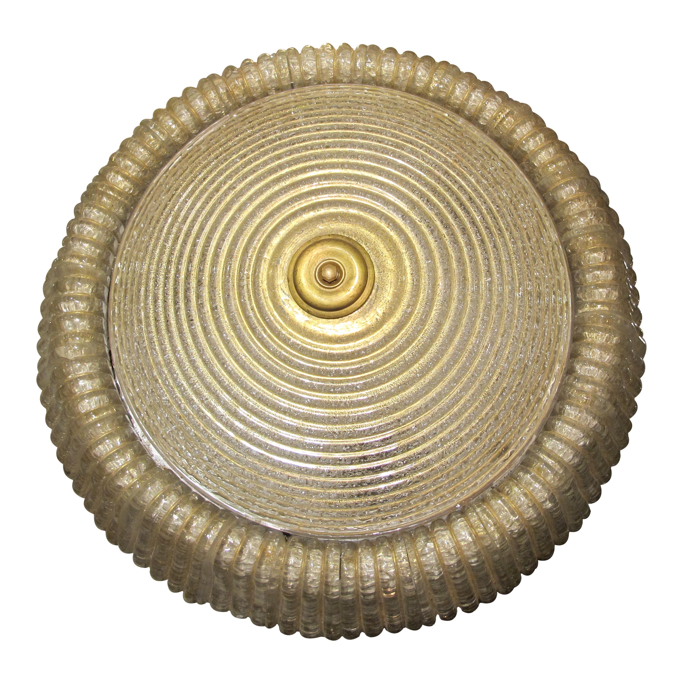 Este plafón/plafón redondo de cristal de Murano, fabricado por el prestigioso fabricante italiano Seguso Vetri d'Arte, presenta un diseño atemporal. Su forma circular presenta una textura delicadamente estriada, realzada por brillantes detalles