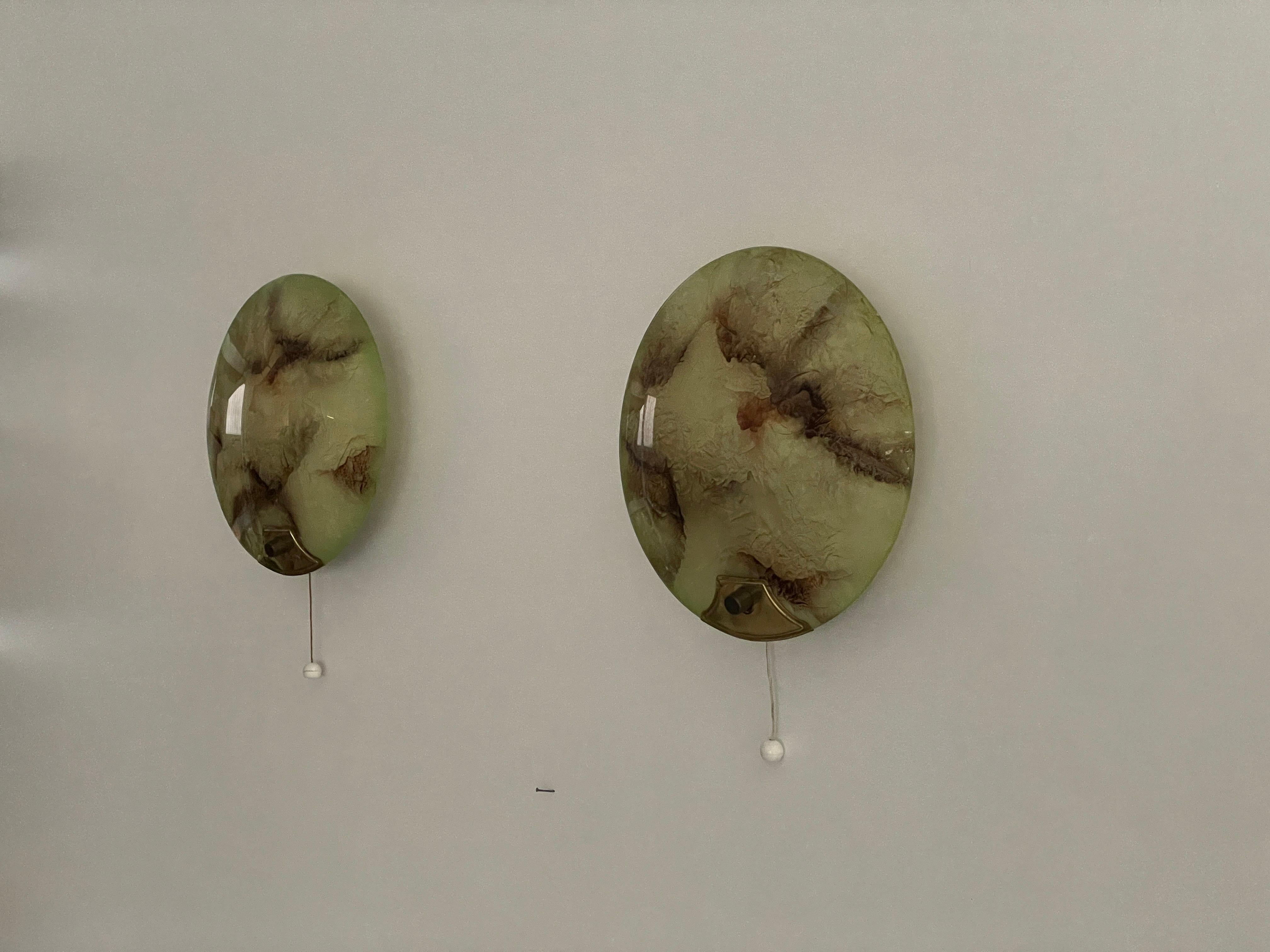 Paire d'appliques rondes du milieu du siècle en verre vert et laiton, années 1950, Allemagne
Appliques très élégantes et minimalistes
La lampe est en très bon état.

Ces lampes fonctionnent avec une ampoule standard E27. 
Câblé et utilisable dans