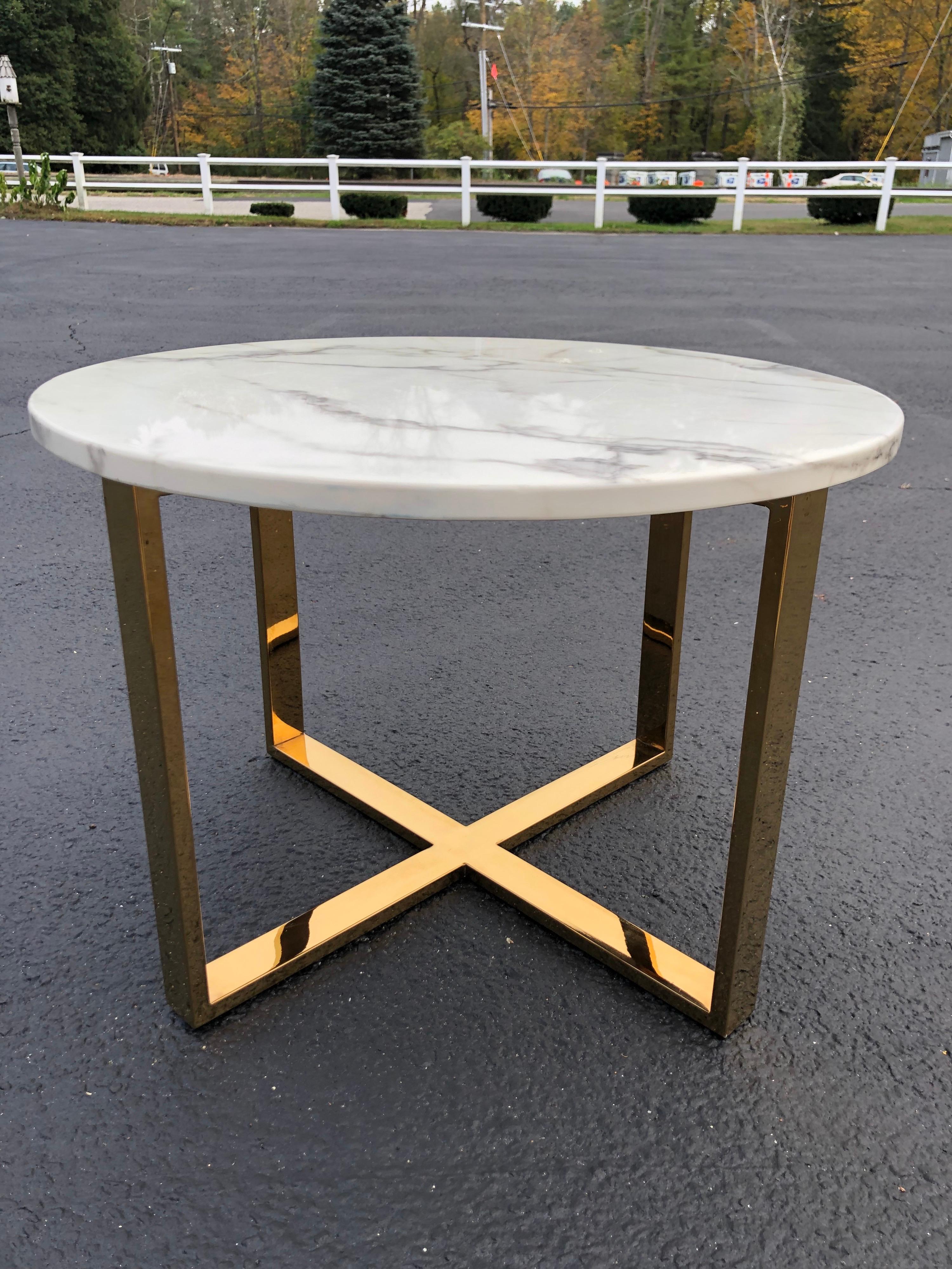 Mid Century round marble and brass table. Classic Carrara white marble top with gray veins throughout. Sits atop a modular brass base. Minimalist modern lines. Use as a side table of smaller coffee table.