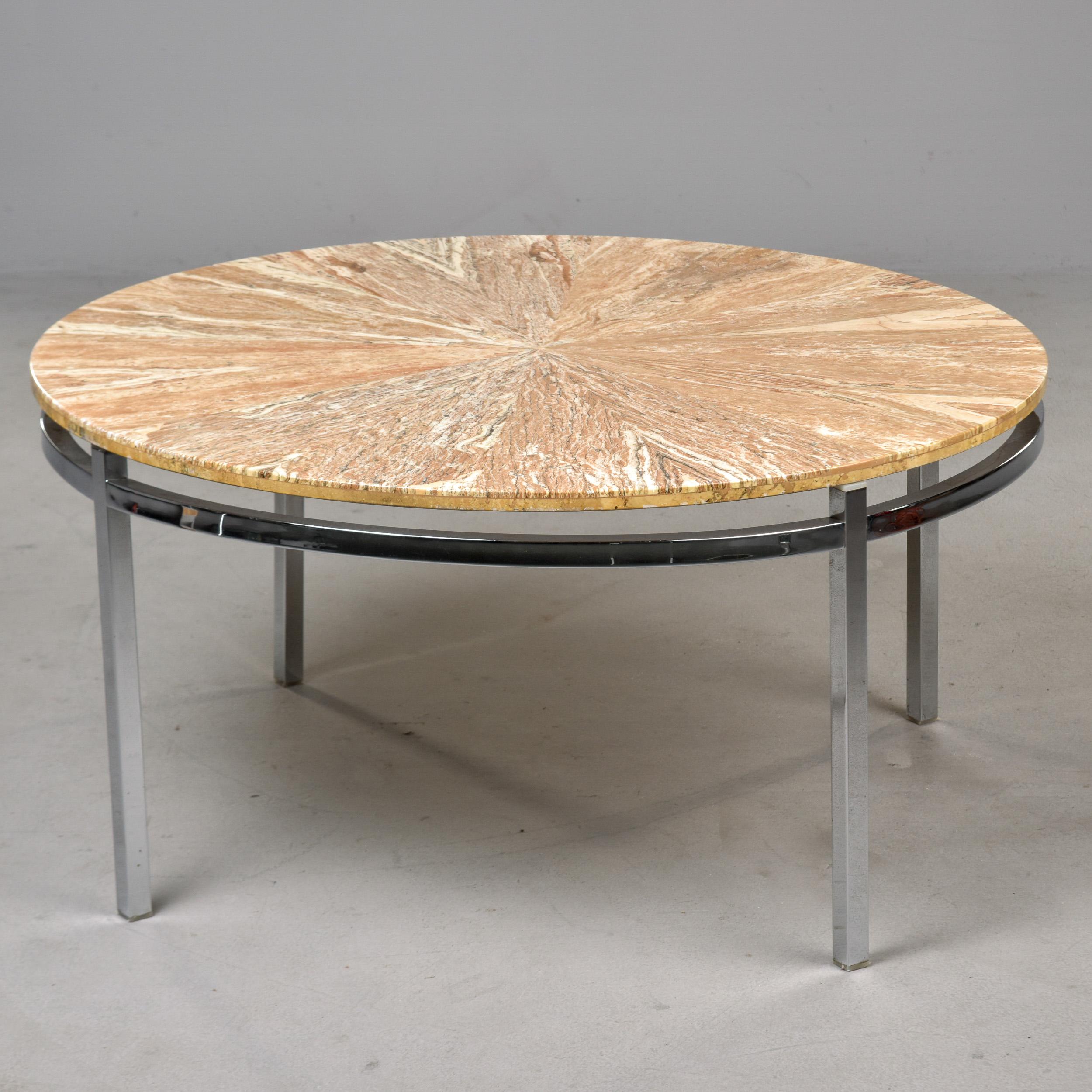 Found in England, this round marble topped coffee or cocktail table dates from the late 1970s / early 1980s. Polished chrome base features four square legs.  Round marble top has features stone veneer panels arranged like pie wedges to form a circle