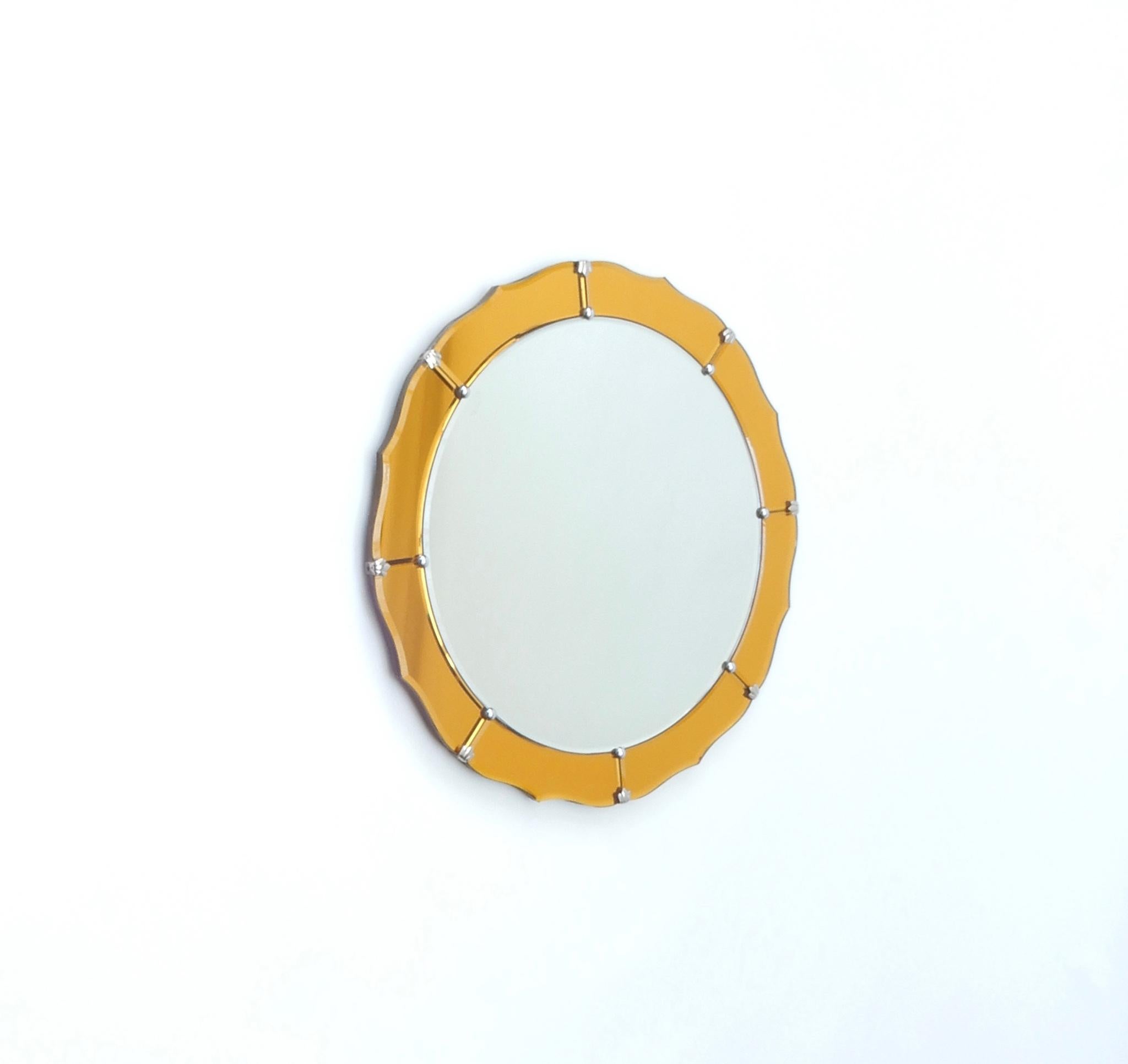 Midcentury round mirror with yellow orange frame.