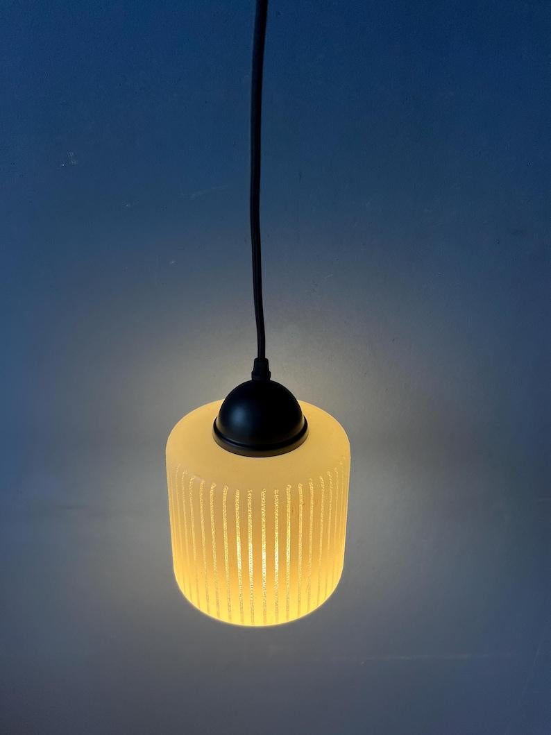 Piccola e graziosa lampada a sospensione in vetro a forma di Can con motivo a righe. La luce fuoriesce magnificamente attraverso la struttura in vetro. La lampada richiede una lampadina E27/26 (standard).

Informazioni aggiuntive:
Materiali: Vetro,