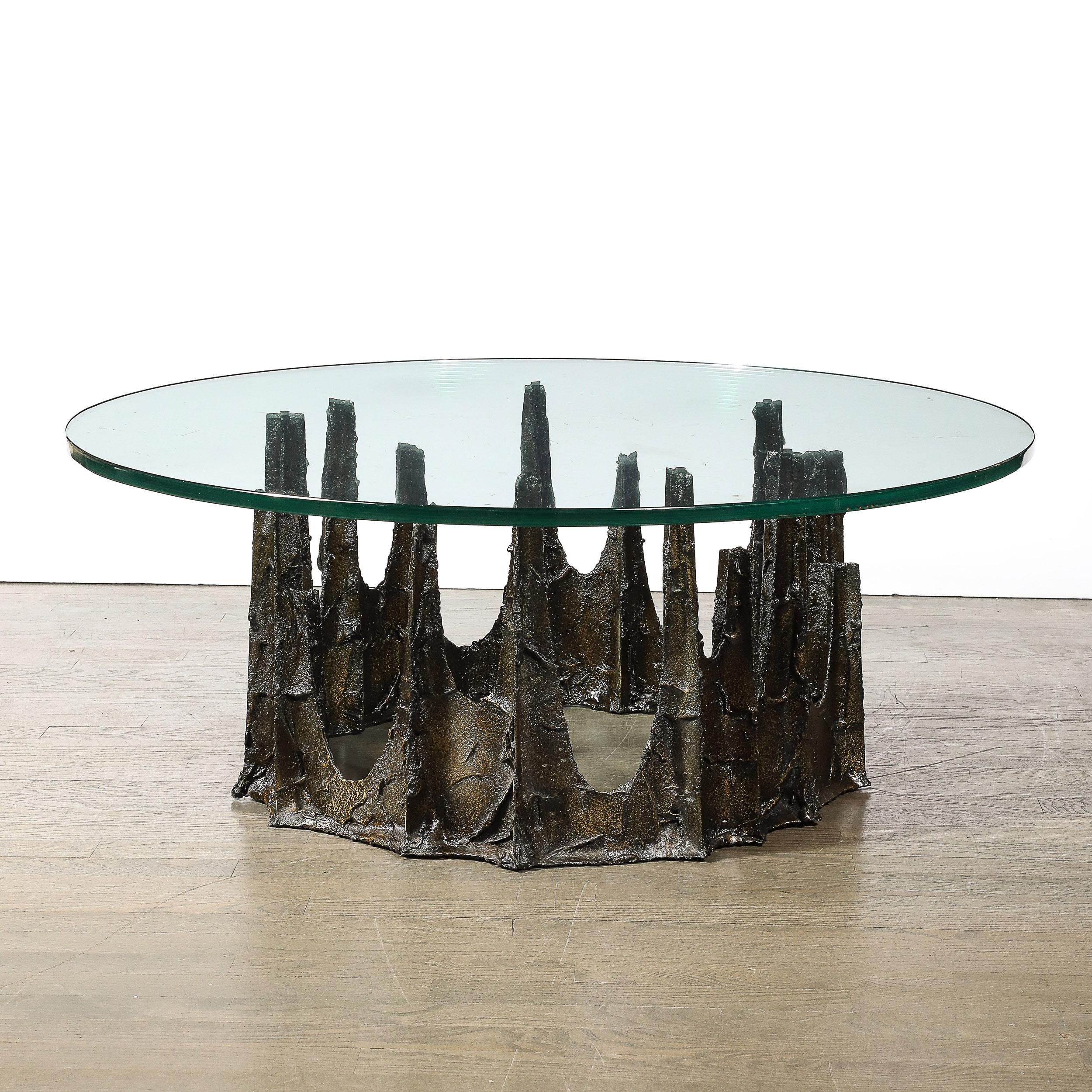 This remarkable mid-century modernist cocktail table, designed by the acclaimed American artist Paul Evans circa 1970, features a distinctive round stalagmite form crafted in bronze. Known for his innovative approaches to metalwork and furniture