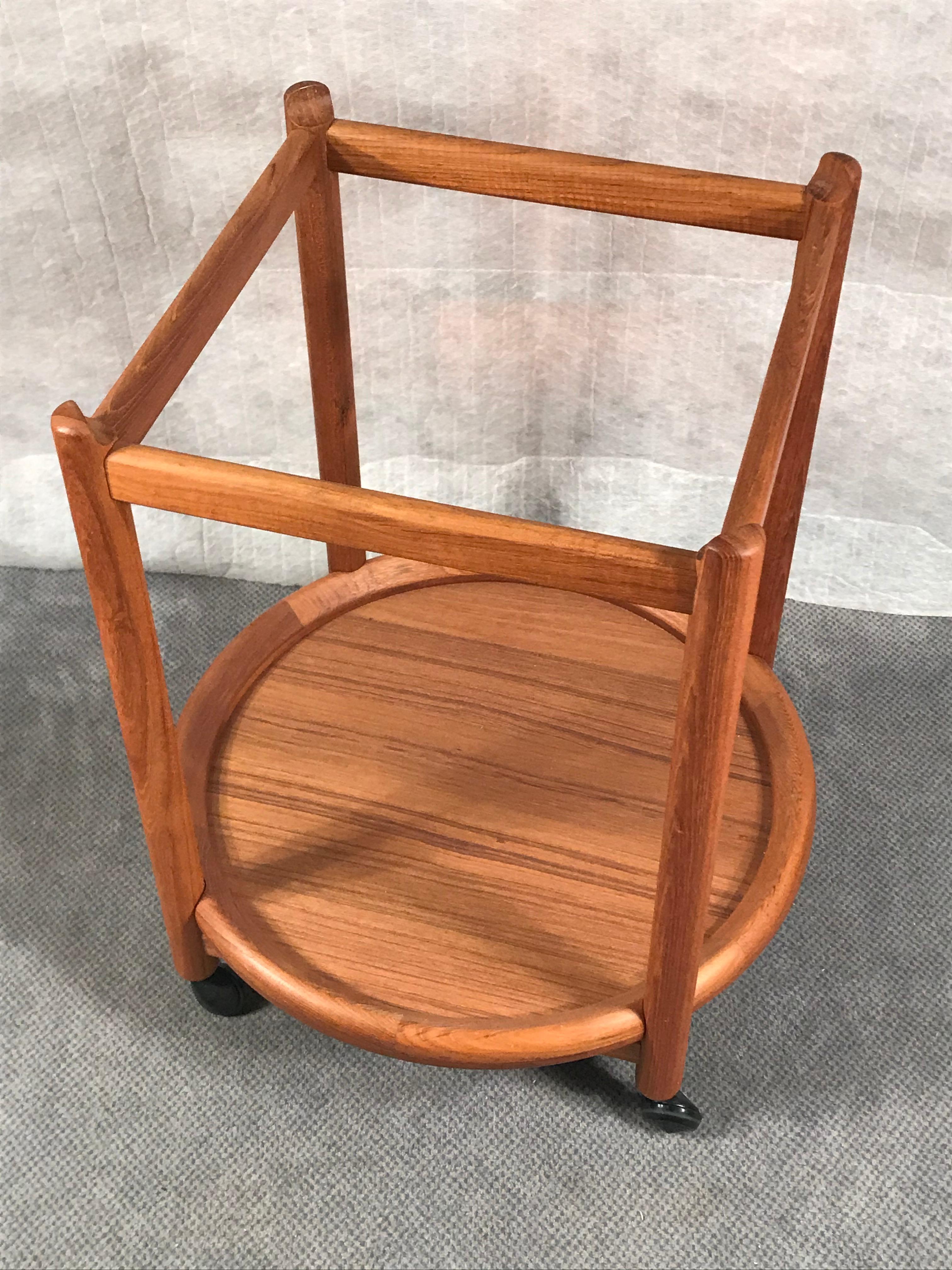 Mid century round tea or bar cart, Denmark 20th century. Teakwood. 
The small cart or side table stands on casters and has two shelves. The upper one is removable and can be used as a tray. 
The tea cart is in very good vintage condition.