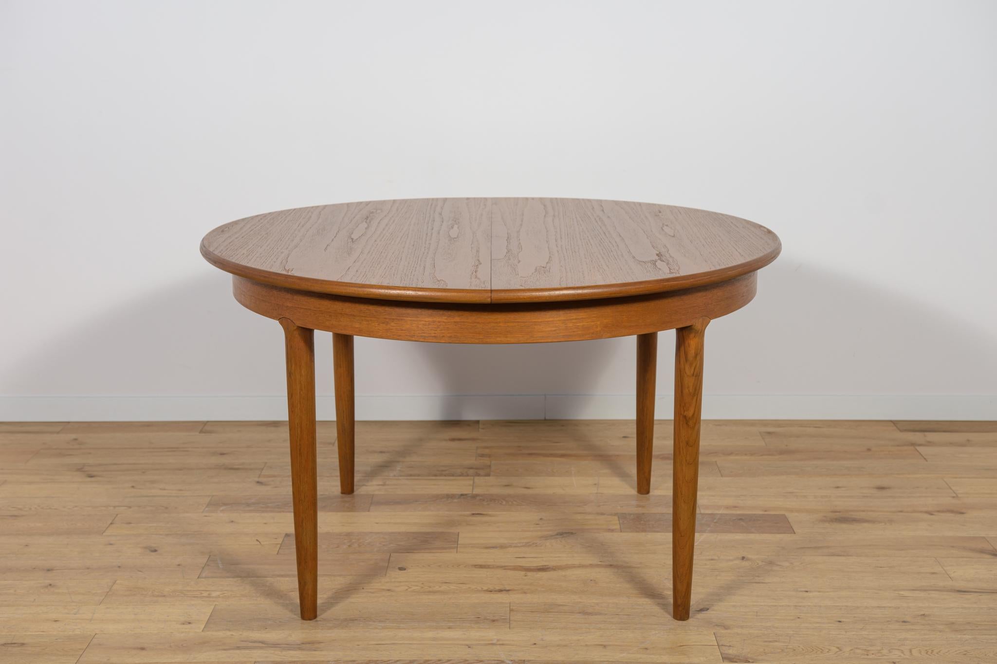 La mesa extensible se fabricó en la década de 1960 en Gran Bretaña. Mesa de comedor de forma redonda, tiene bordes macizos reforzados y patas perfiladas, lo que le confiere una elegancia única. Muebles tras una reforma profesional de carpintería. Se
