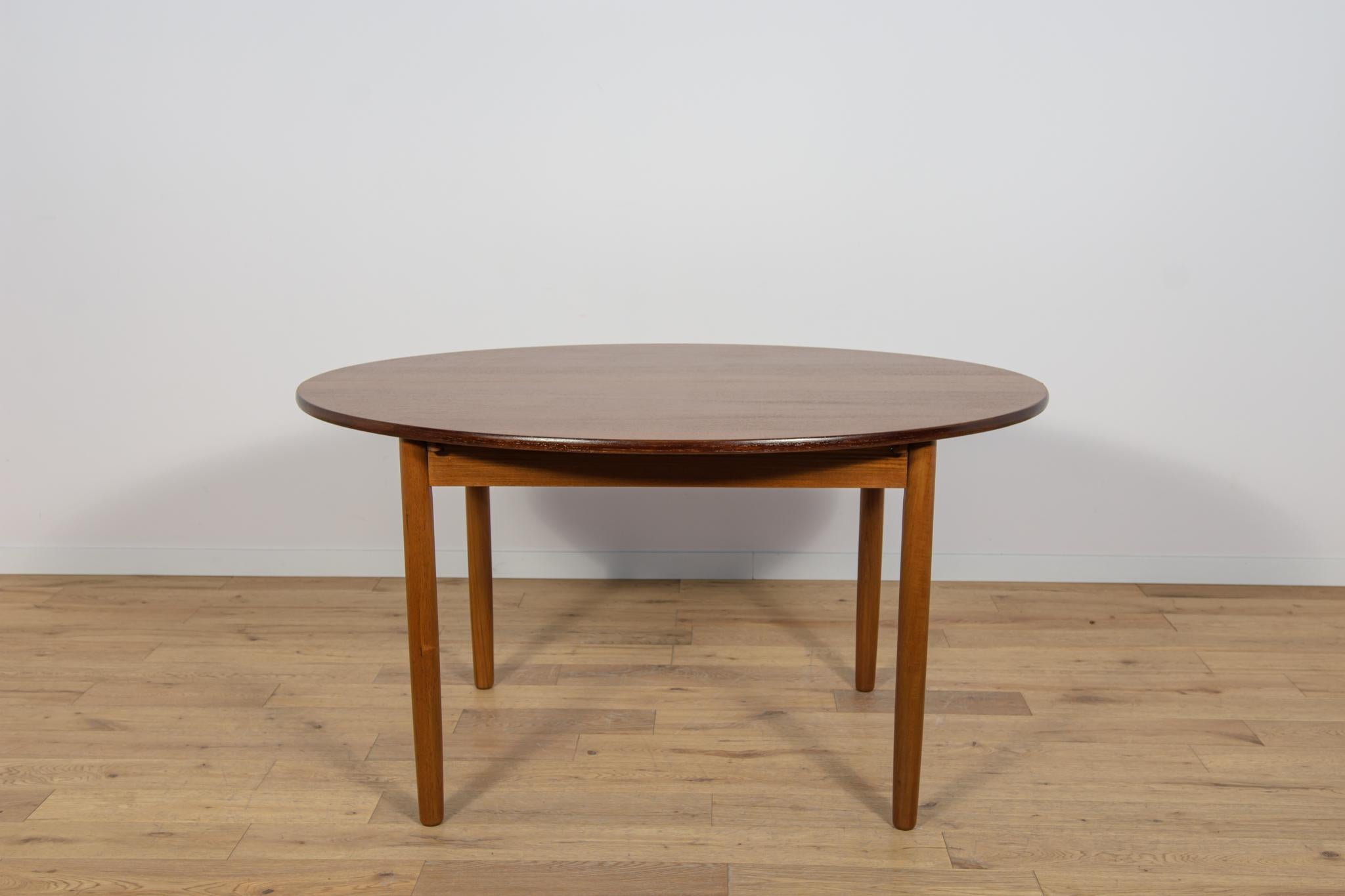 Round teak wood table produced in the UK in the 1960s. The table features an interesting grain. The furniture has undergone comprehensive carpentry renovation. It has been stripped of the old surface, stained with oak stain, and finished with a