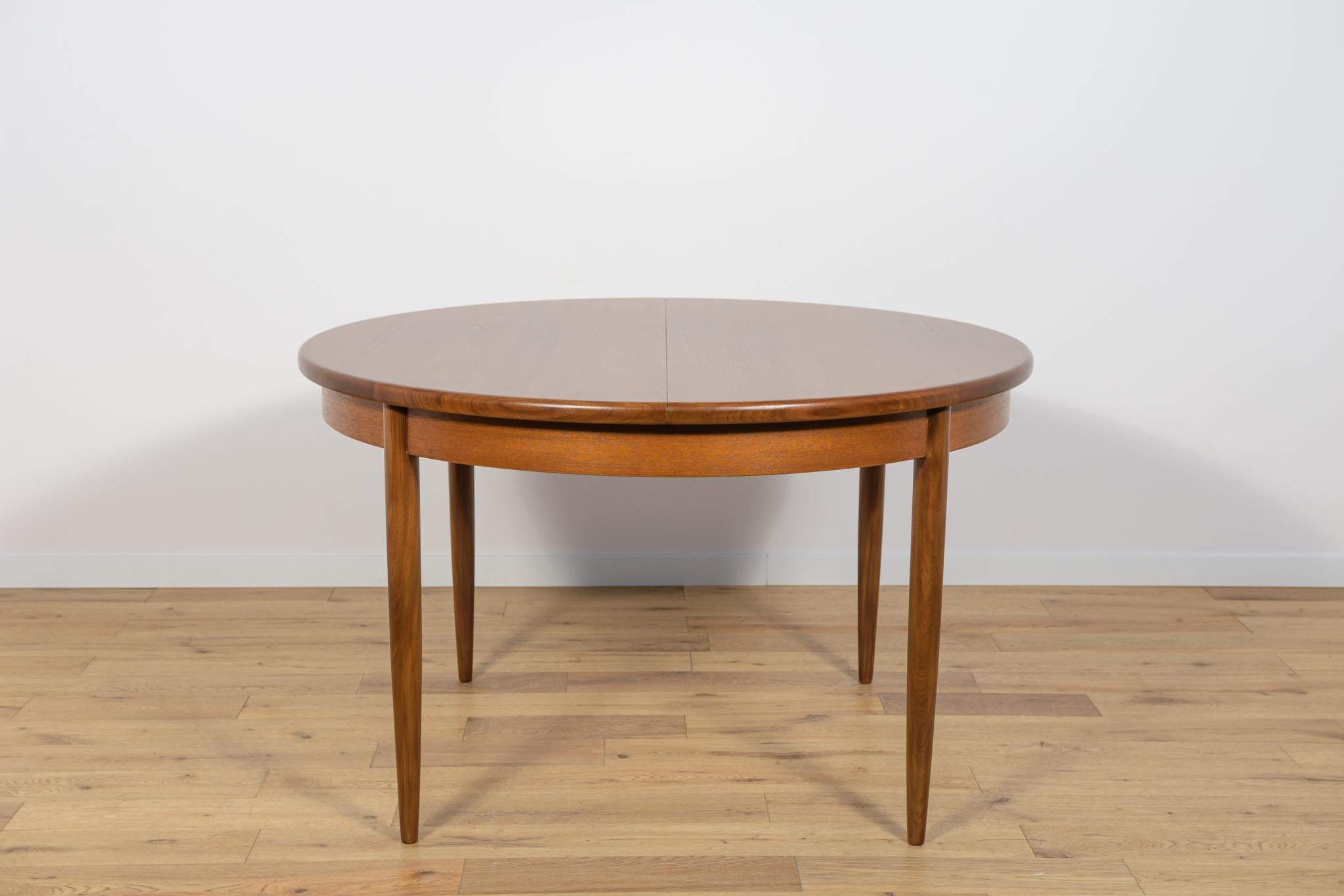 This round extendable dining table was produced by G-Plan in the 1960s. The table has profiled reinforced edges of the top. Teak elements cleaned old coating and painted in a oak stain and finished with strong semi matt lacquer. The table has a