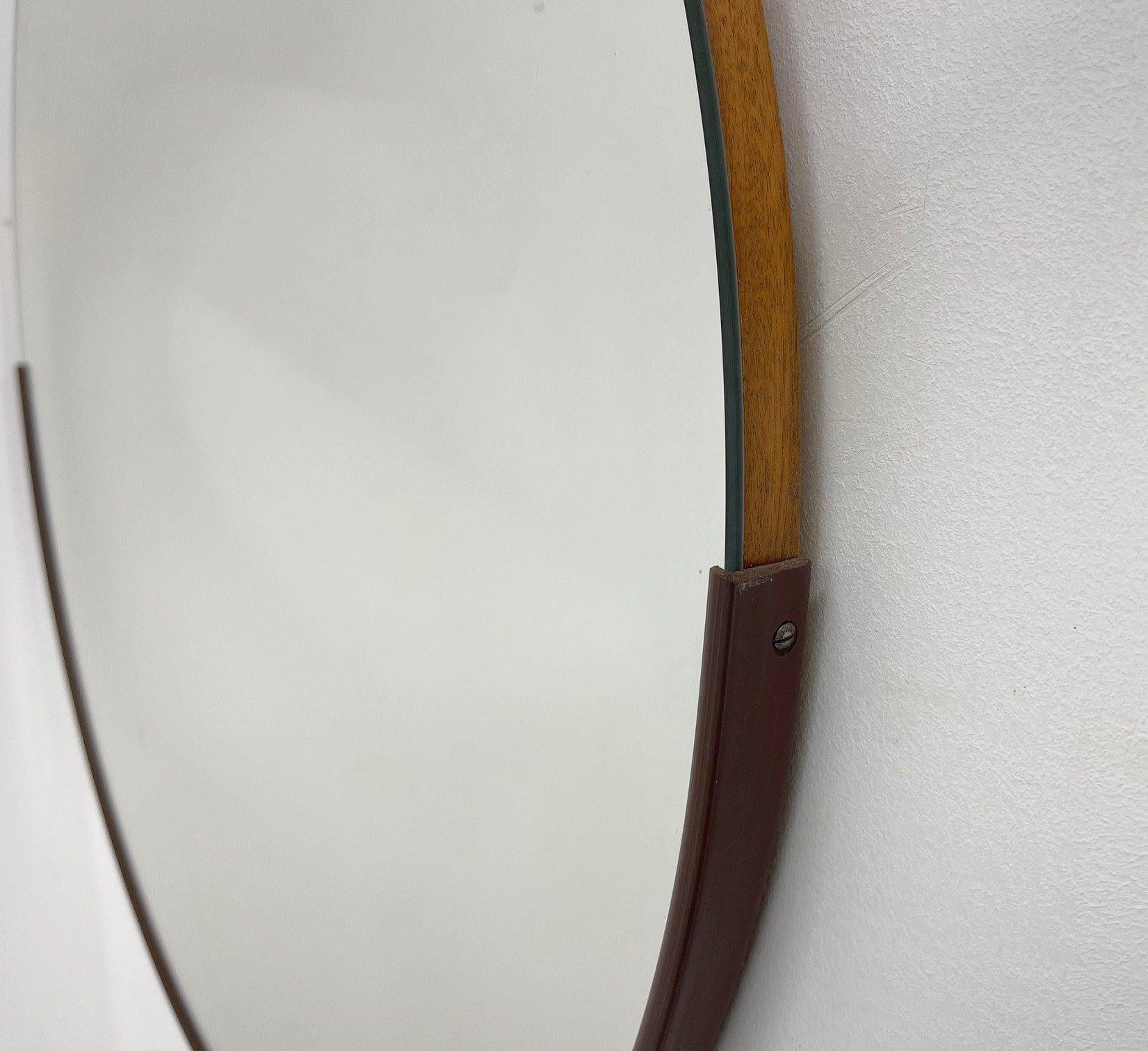Round wall mirror with plastic rim at the bottom part from the 1970's.