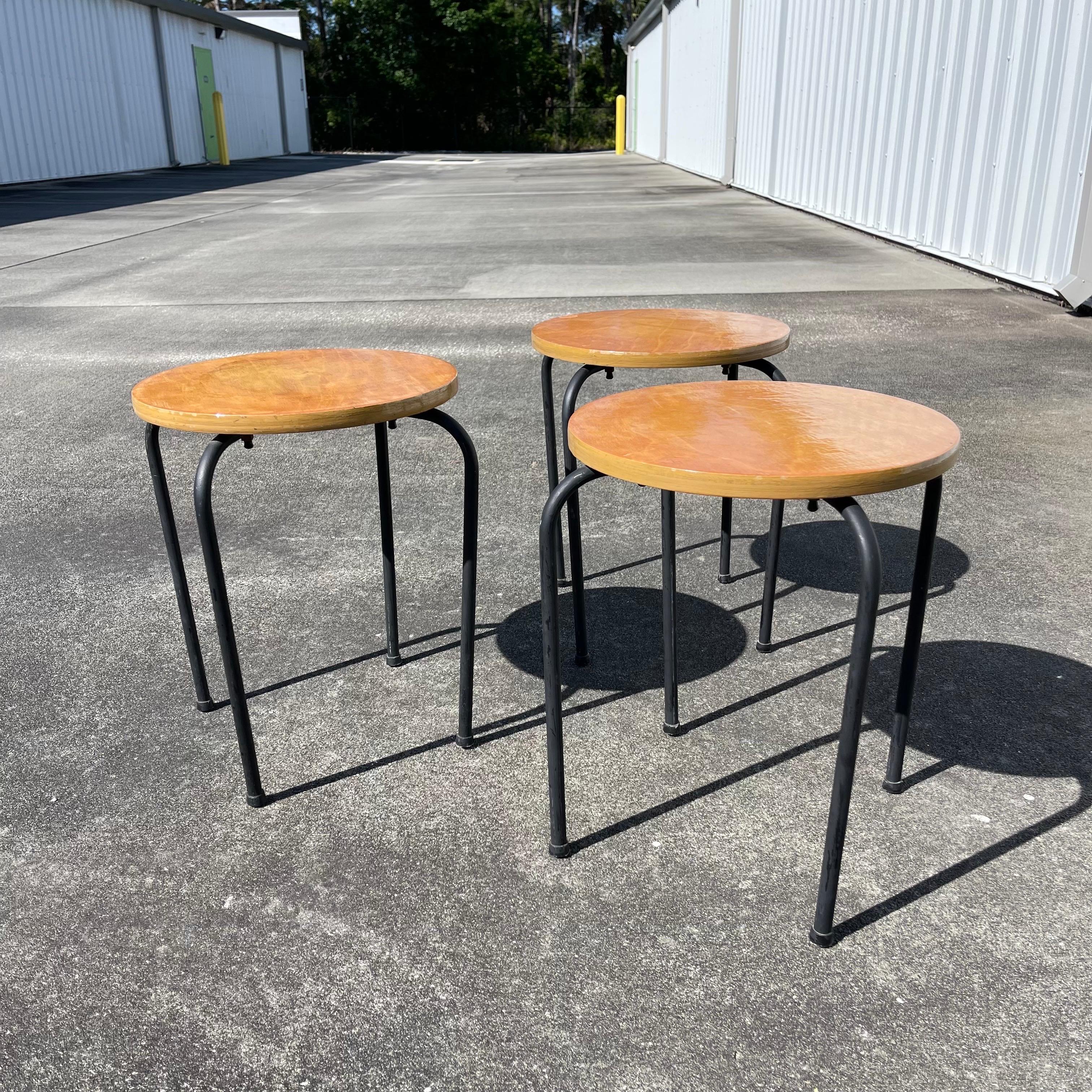 Juego de 3 mesas o taburetes apilables redondos de madera con patas de metal.