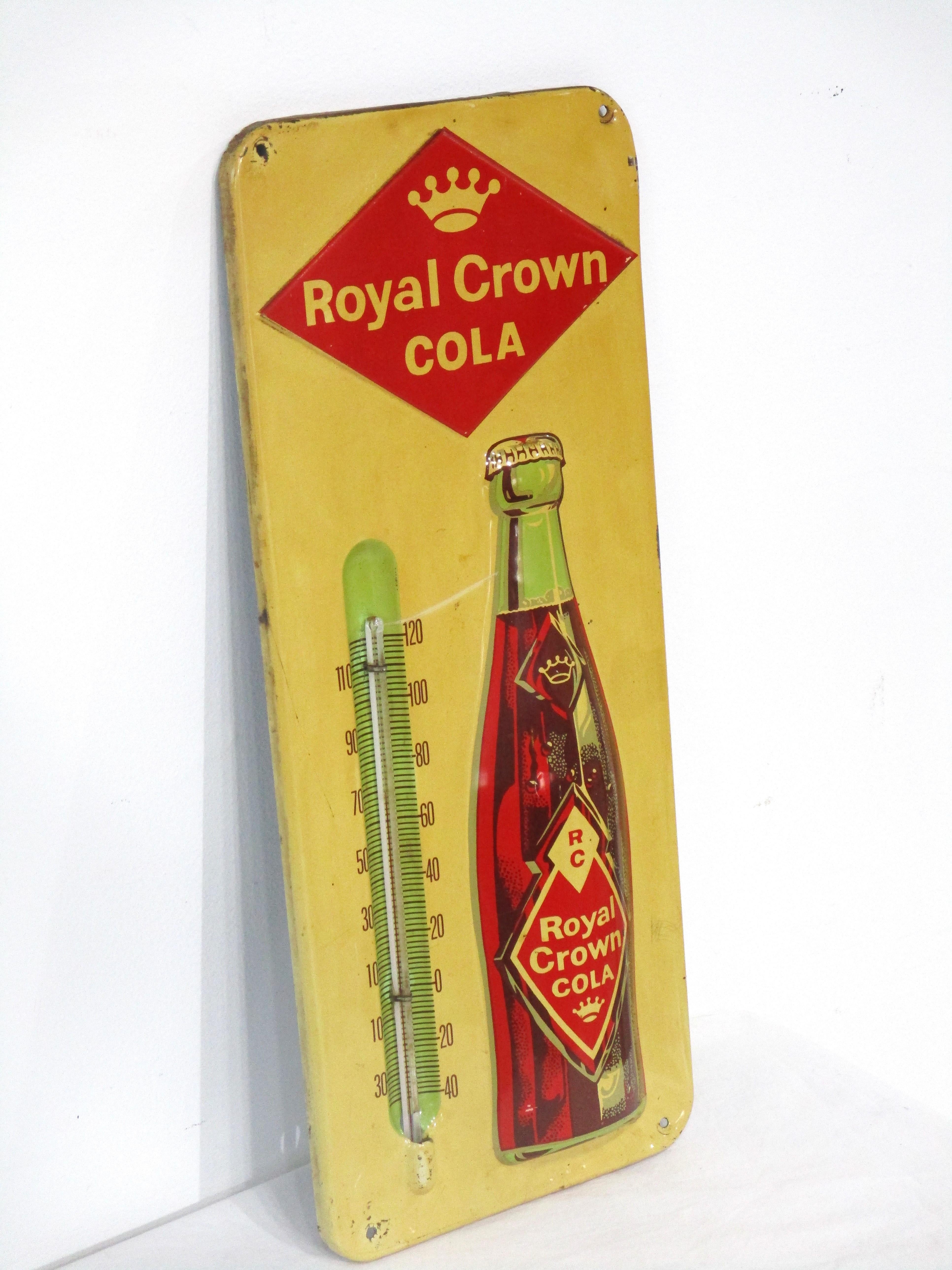 Thermomètre publicitaire Royal Crown Cola lithographié en métal avec bouteille embossée donnant à la pièce un certain intérêt dimensionnel. Il s'agit d'un modèle de production précoce doté d'un logo angulaire en forme de diamant, datant de la