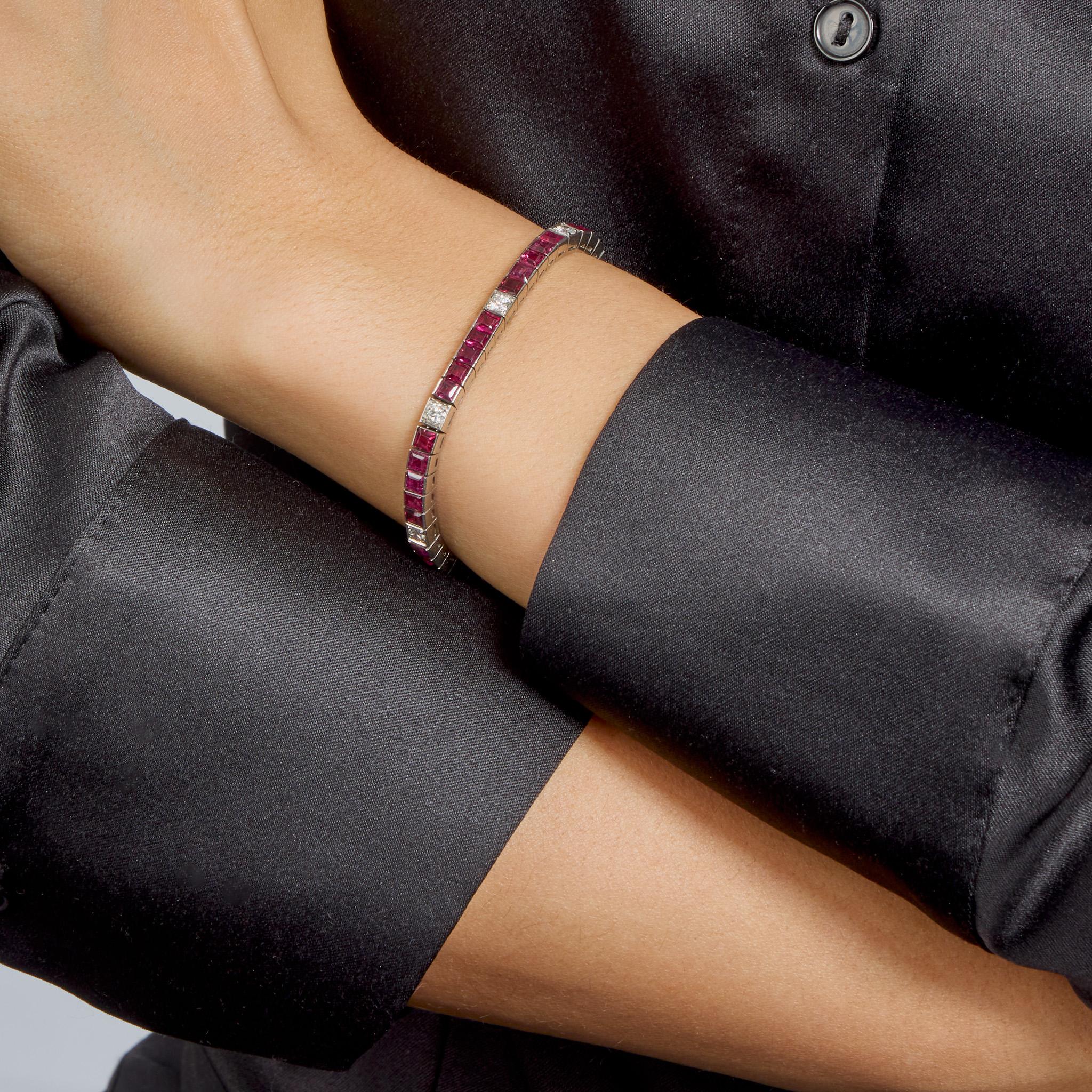Created in the 1950s, this platinum line bracelet is set with rubies and diamonds. It is designed as a channel-set line of square step-cut rubies, approximate total weight 7.20 carats, interspersed with old European-cut diamonds. Ever modern and