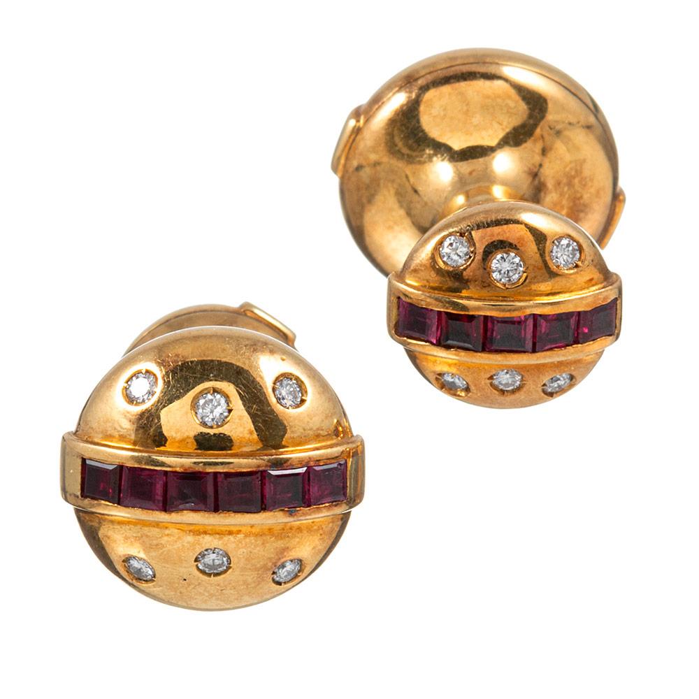 Charming button-shaped cufflinks of 18 karat yellow gold adorned on both sides with a stripe of ruby and peppered with brilliant round white diamonds. They are engineered with a spring, so the opposing sides gently pull away from each other to allow