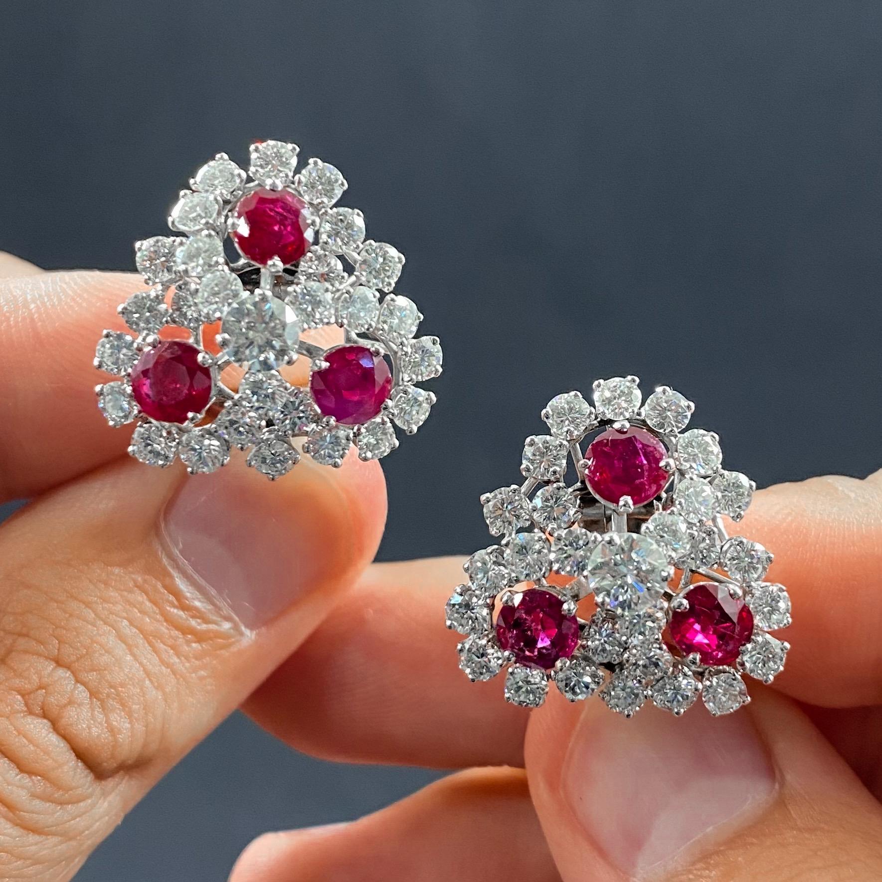 A pair of Mid-Century ruby and diamond trefoil cluster clip-on earrings in platinum, Portugal, 1950s/1960s. Each earring is designed as stylized trefoil with a round brilliant-cut diamond claw-set to the center, the three petals embellished with a