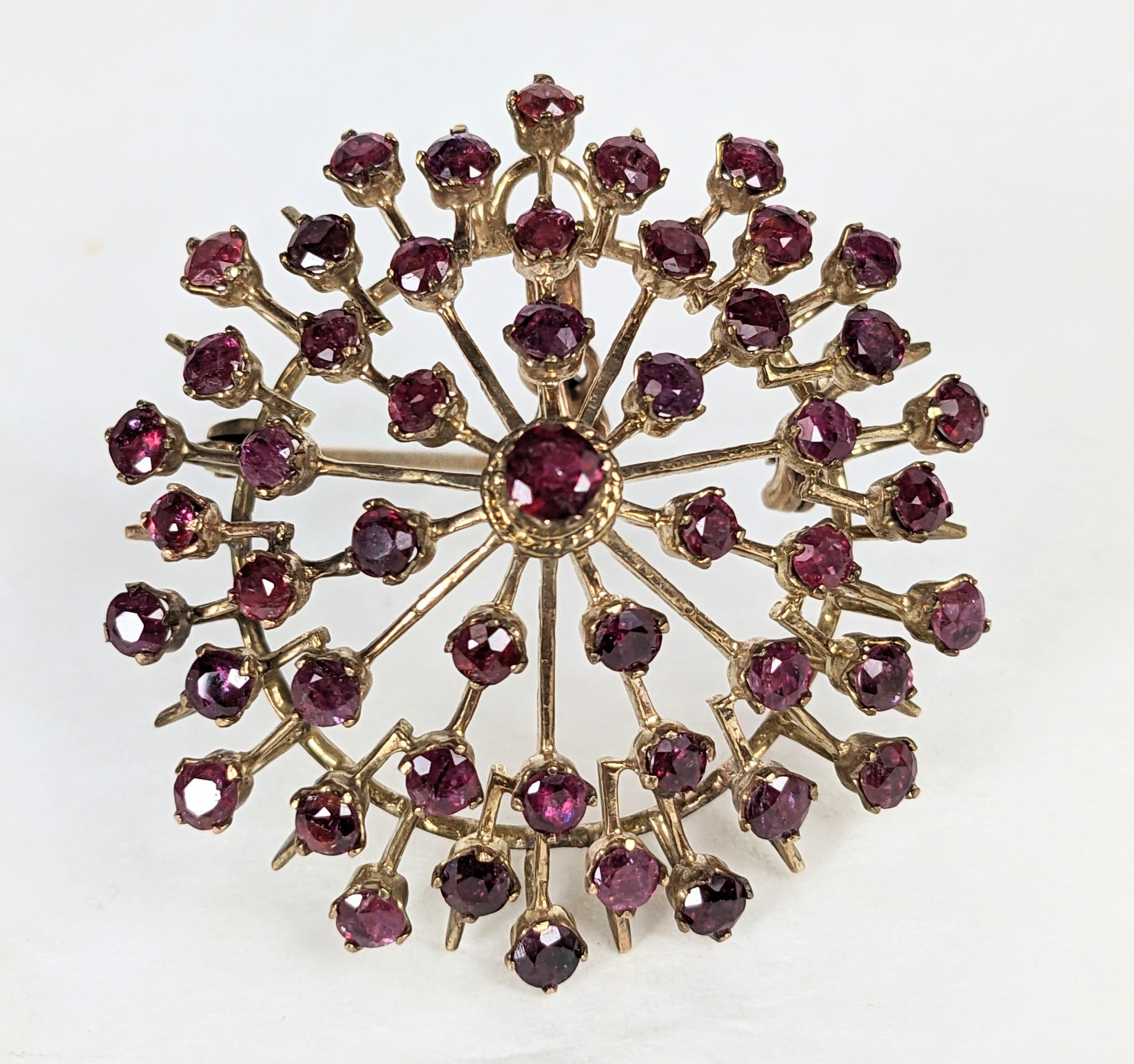 Mid Century Ruby Starburst Brooch/Pendant from the 1960's set in 14k gold. Knife edge gold wire set in a pyramid shape with genuine rubies scattered along the top. Pendant fitting hidden in back. 1960's USA. 1.75