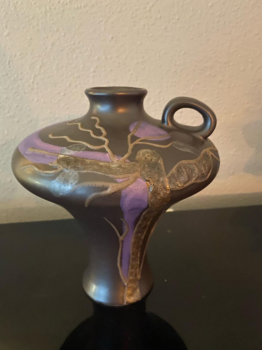 Beautiful art pottery and unusual piece by Ruscha with a strong art nouveau influence in its shape and decoration. It is glazed in a dark brown with variegated purple and light grey decoration. Marked on the bottom.