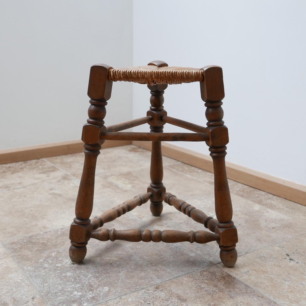 An unusual early to mid-20th century three legged stool. 

Turned oak or similar wood with a rush top in good condition. 

Sturdy and infinitely stylish. 

French in origin. 

Dimensions: 41 W x 41 D x 47 seat height x 27 width of top in cm.