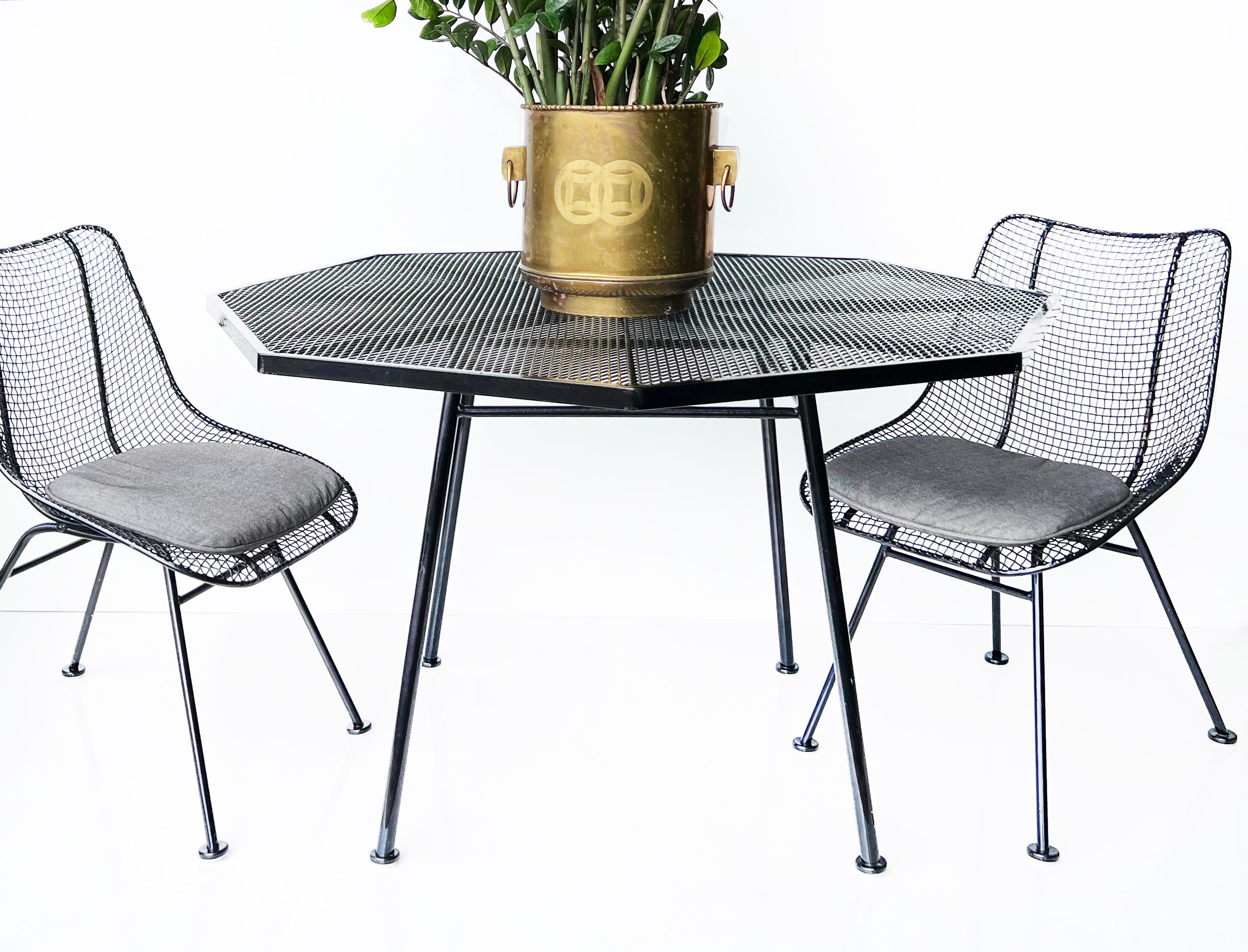 Mid-century Russell Woodard Octagonal Mesh Dining Table 

Offered for sale is a Mid-century Modern Russell Woodard octagonal iron mesh dining table. There is a center hole to place an umbrella. The table is shown with Woodard Sculptra chairs for