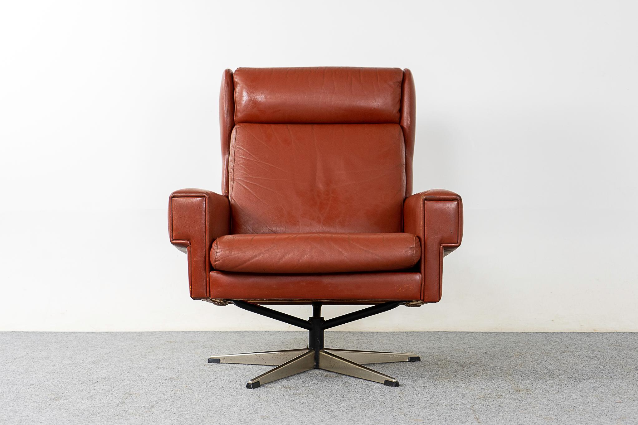 Leather Danish swivel chair, circa 1960's. High back provides excellent neck support. Beautiful deep rust tone leather in great vintage condition. Robust metal base with original feet.

Please inquire for remote and international shipping rates.