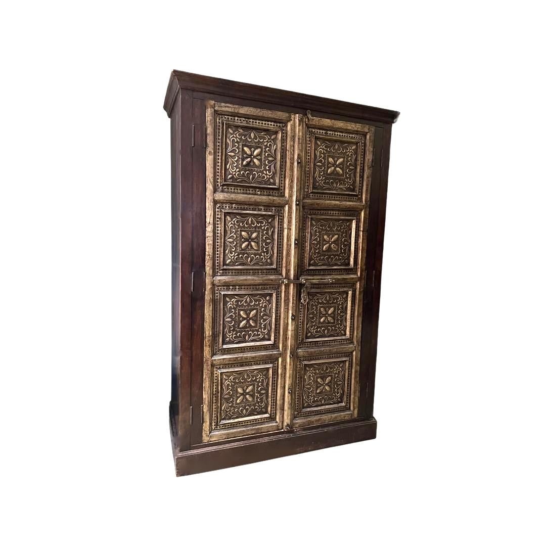 Mid-20th Century large European-style bronze front rustic wood armoire with ornate haveli brass overlay on substantial doors. Handcrafted of solid wood construction and patinated ironwork and metal stud work and handles. This Old-World style hefty