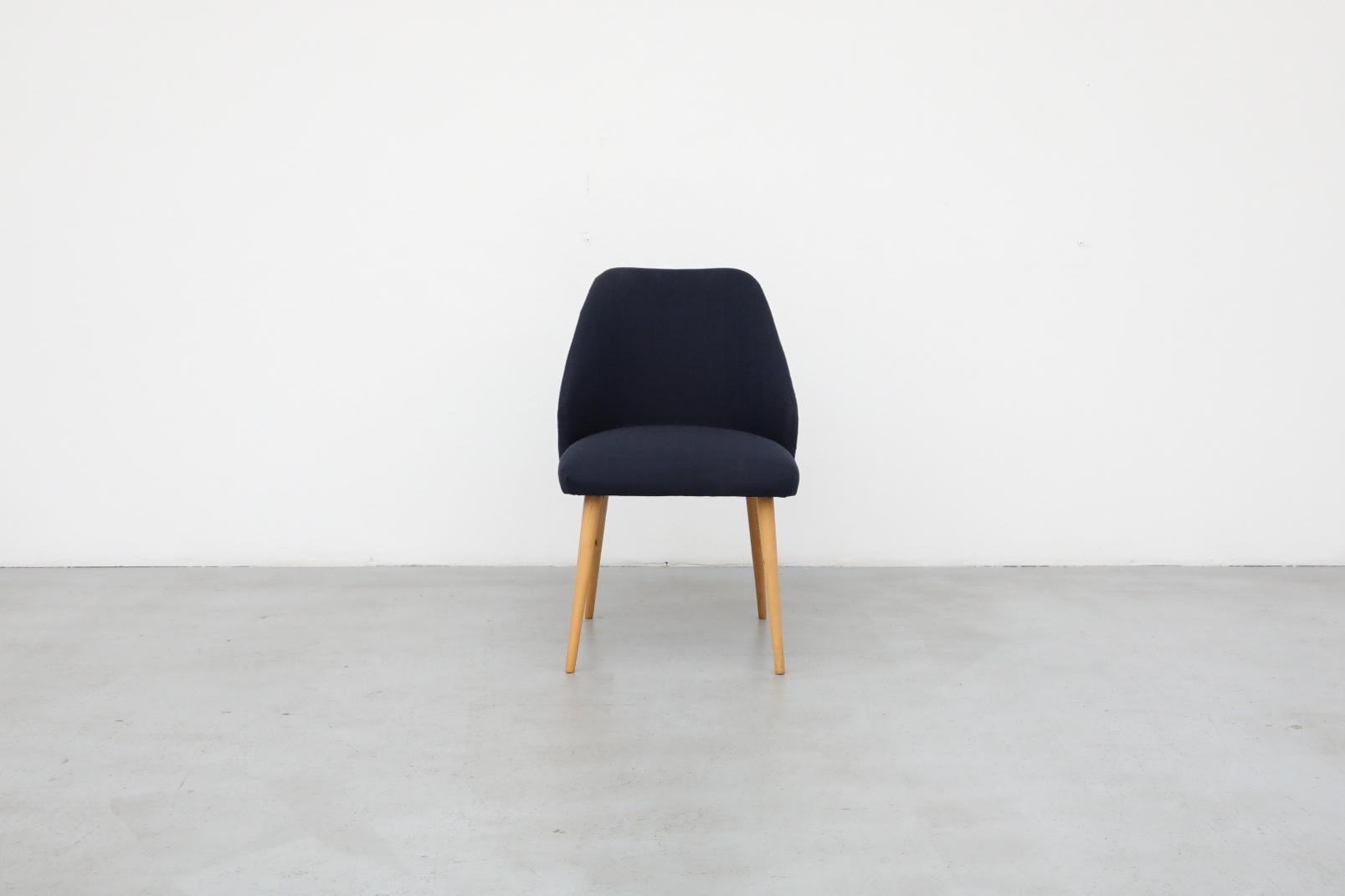 Mid-Century Saarinen style accent or cocktail chair with natural birch tapered legs and newer navy fabric. In otherwise original condition with some visible wear consistent with its age and use. Many similar chairs available in varying sizes, shapes