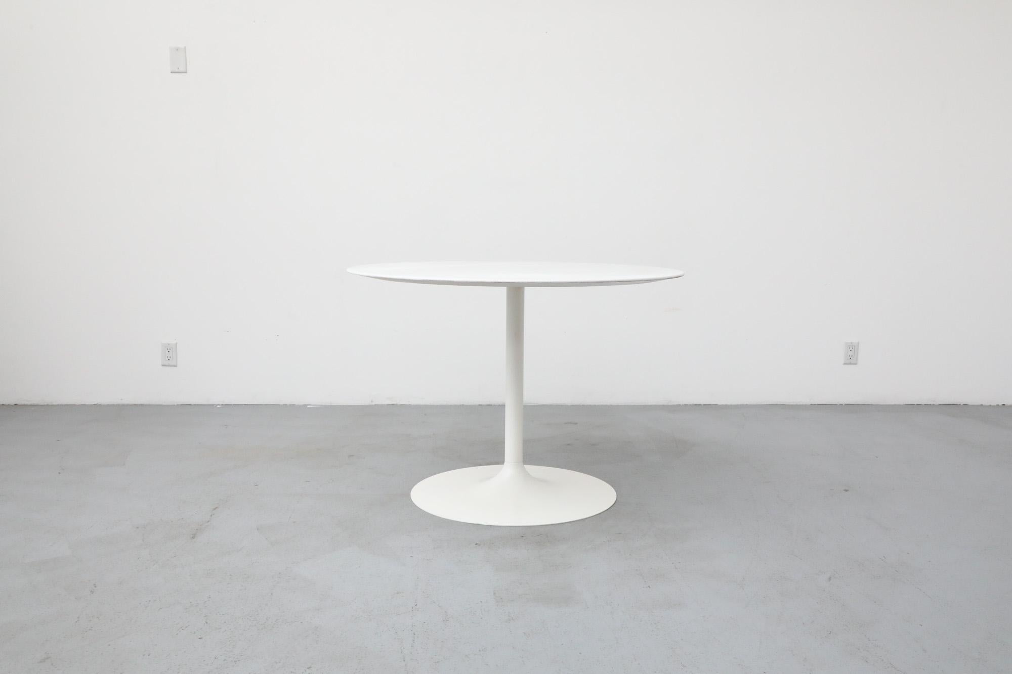 Table de salle à manger de style tulipe du milieu du siècle dernier. La base de la tulipe en acier est de couleur crème, tandis que le dessus est d'un blanc éclatant, tous deux récemment peints. La table présente une usure visible correspondant à