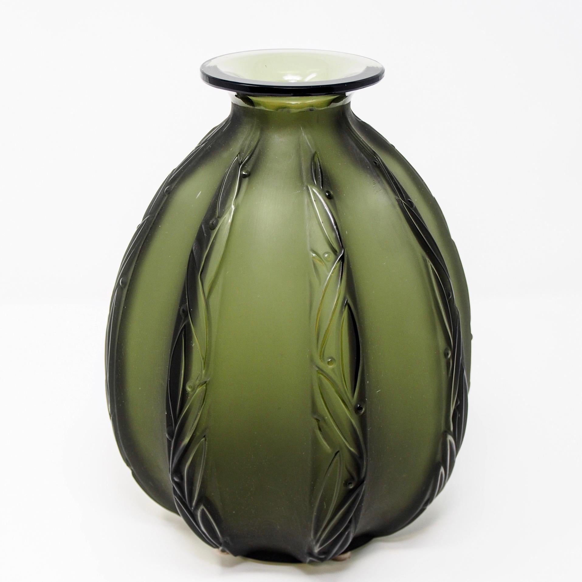 Sabino art glass vase in smoky green color features ribbed body with stream lined leaf and berry motif, circa 1950s. Etched signature on underside of base.


 