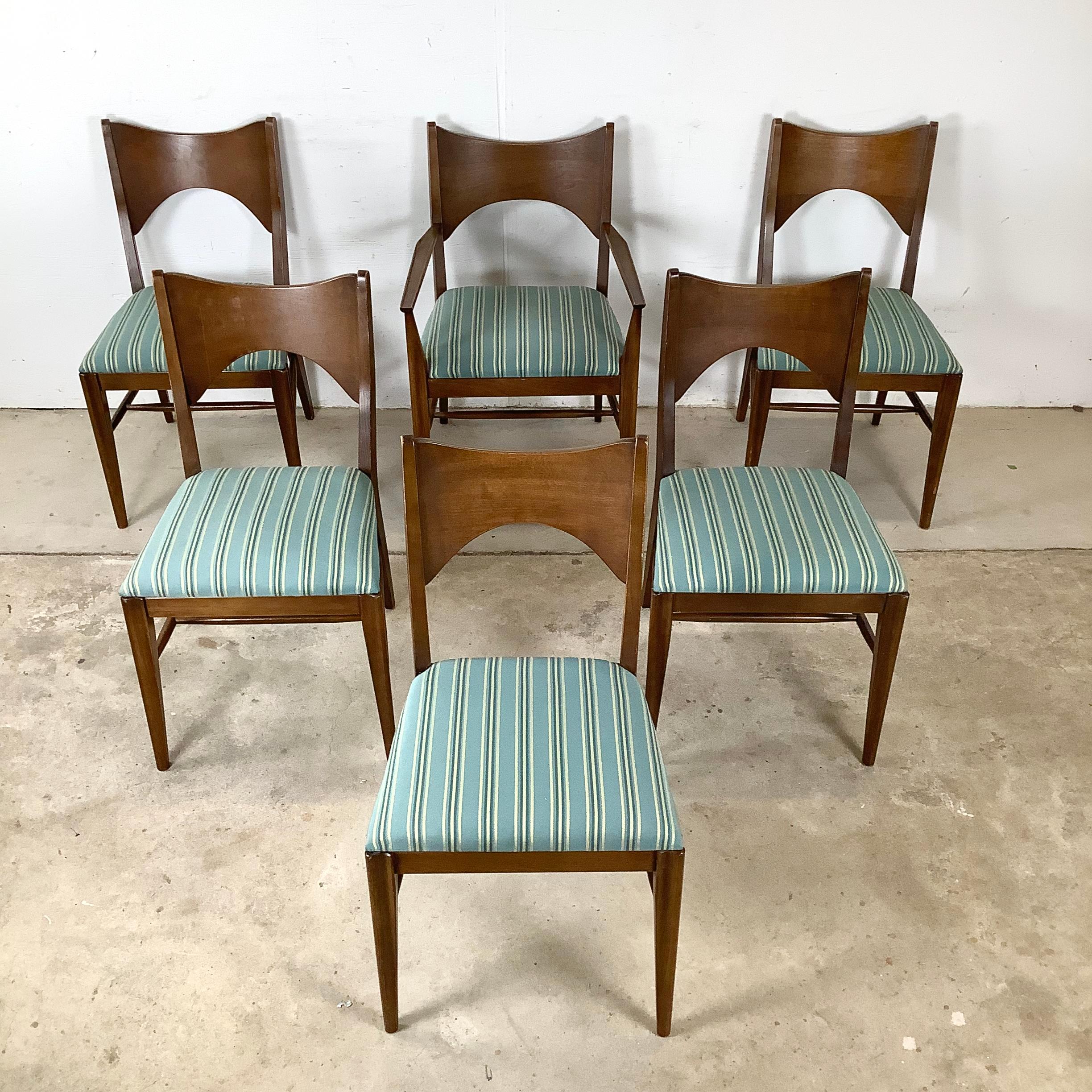 Un set completo di sei sedie da pranzo in noce dell'ambita collezione Saga di Broyhill, questo gruppo incarna la raffinata maestria artigianale e il design distintivo dei mobili moderni americani della metà del secolo. Sono incluse cinque sedie