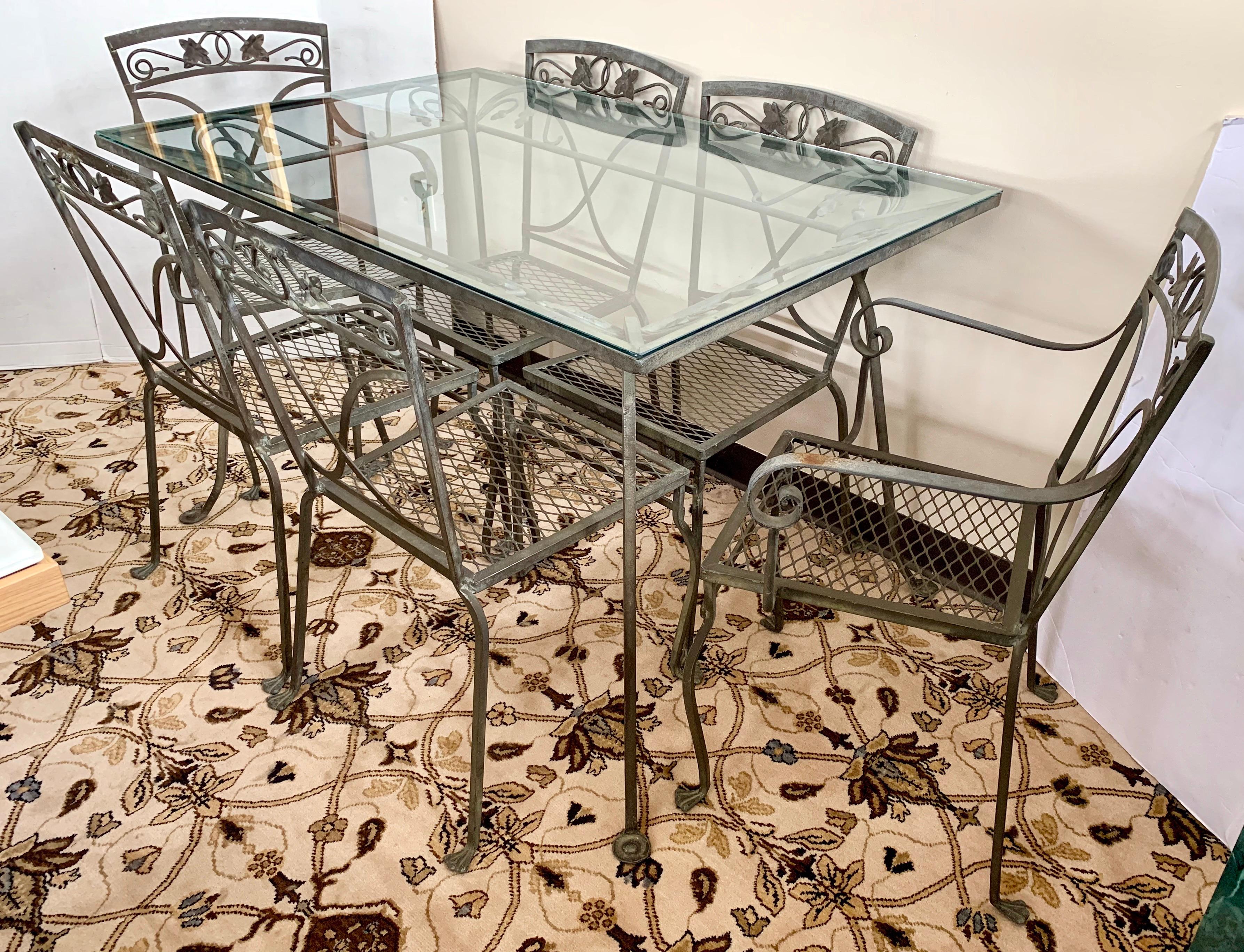 Vintage midcentury 7 pc. wrought iron patio set includes a glass top table with six chairs. They feature heavy wrought iron frames with an acorn and oak leaf Mt. Vernon motif that is one of Salterini's most sought after lines. The set features a