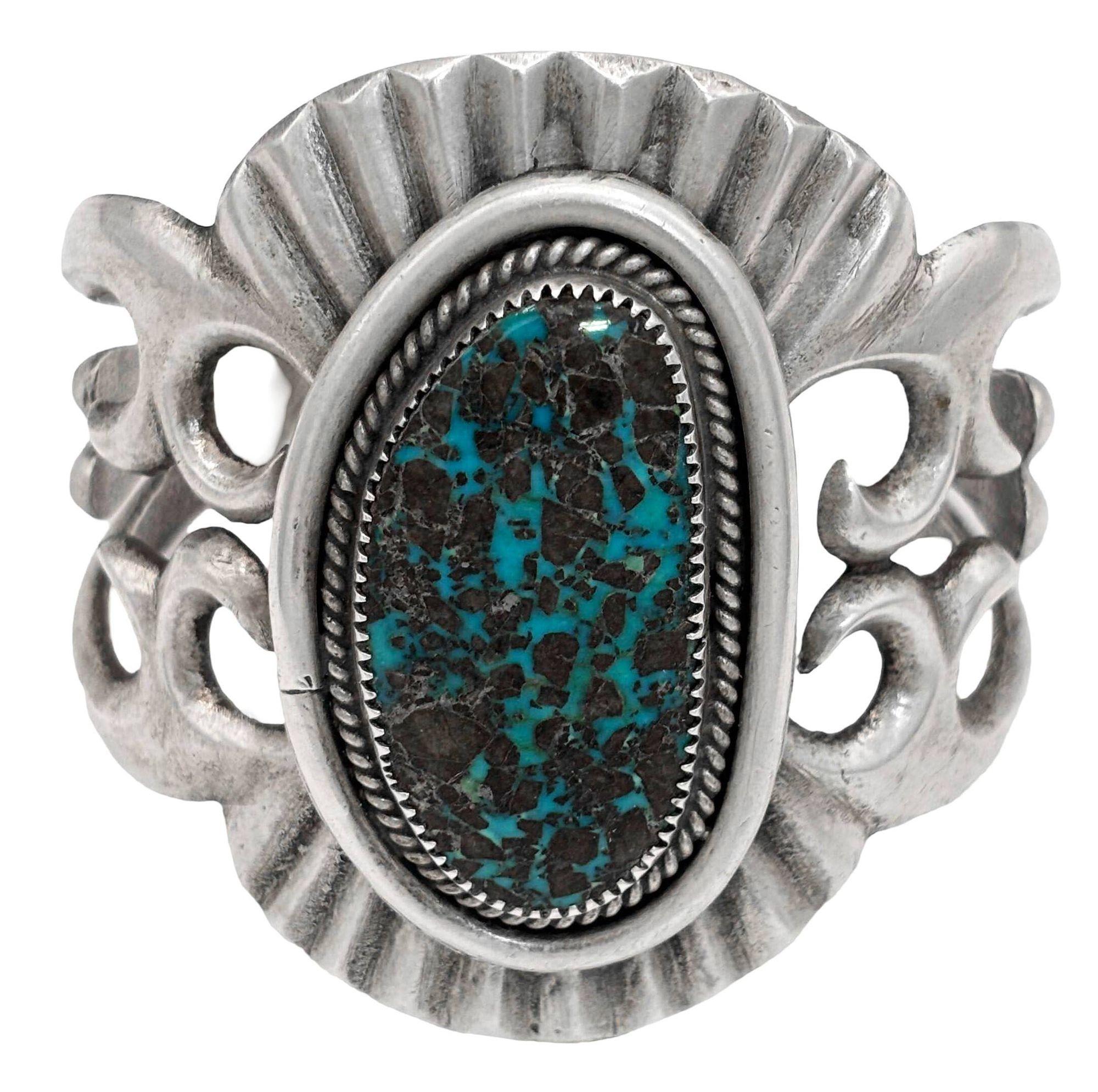 Original sand-cast Navajo sterling silver cuff bracelet features a stunning turquoise stone centerpiece, blending elegance with a touch of Southwestern charm. The intricate silver detailing enhances the vibrant hues of the stone, creating a bold yet
