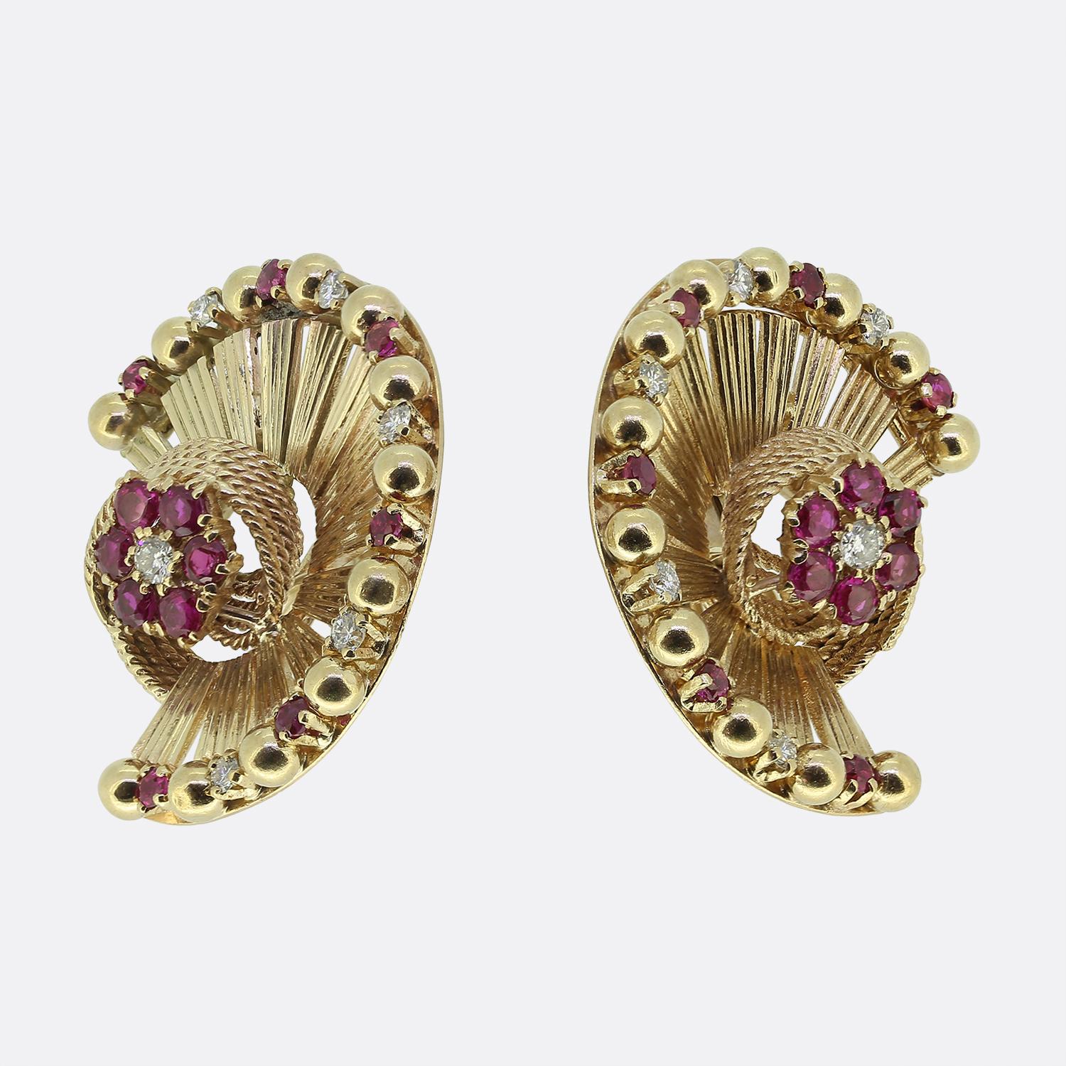 Un impressionante e raro paio di orecchini che risalgono agli anni '60. Gli orecchini sono incastonati con rubini e diamanti e sono realizzati in oro giallo 9ct a ventaglio. I rubini sono di buona qualità e molto probabilmente di origine