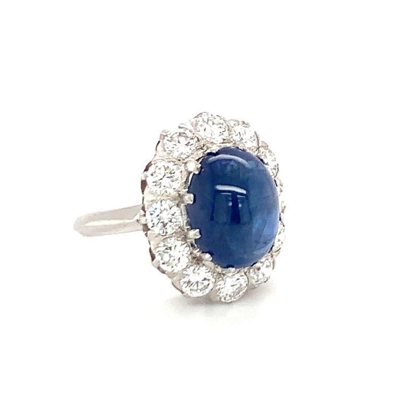 One mid-century sapphire and diamond platinum and 18K white gold ring featuring 1 claw prong set, oval cabochon sapphire weighing 8 ct. The ring is enhanced by 12 round brilliant cut diamonds totaling 2 ct. French made with French Assay marks. Circa
