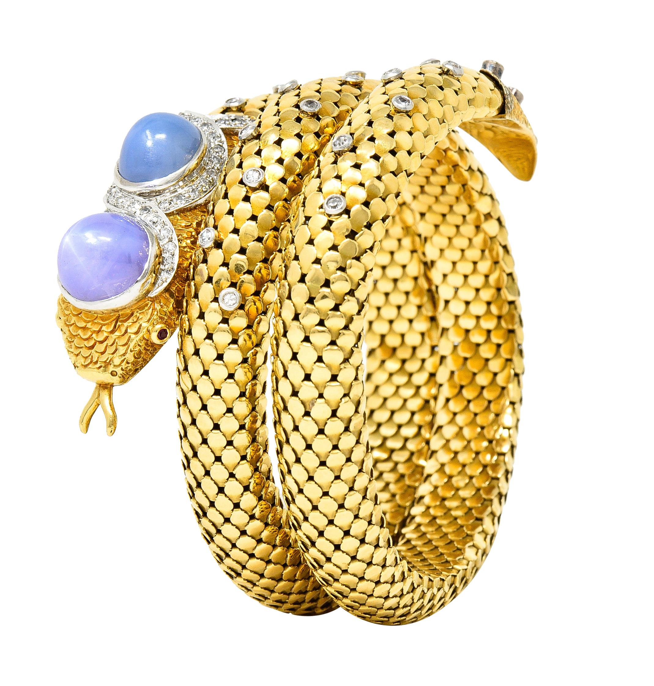 Bracelet is designed as a curling snake with mesh tiered scales and engraved scale texture throughout. Featuring two bezel set star sapphire bullet cabochons weighing approximately 14.60 carats total. One sapphire is translucent light lavender and